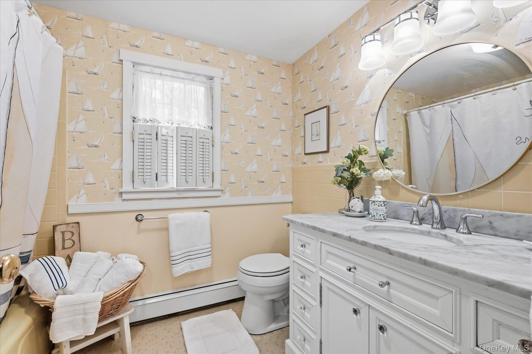 White vanity with a marble countertop, undermount sink, and chrome faucet