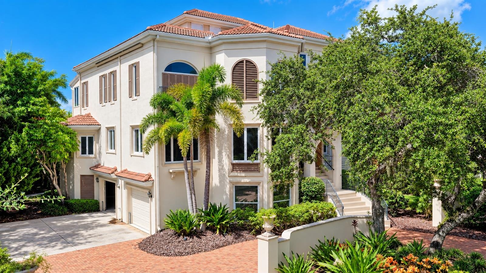 Graceful arched windows, a tile roof and distinctive architectural details give the residence its signature Mizner inspired style.