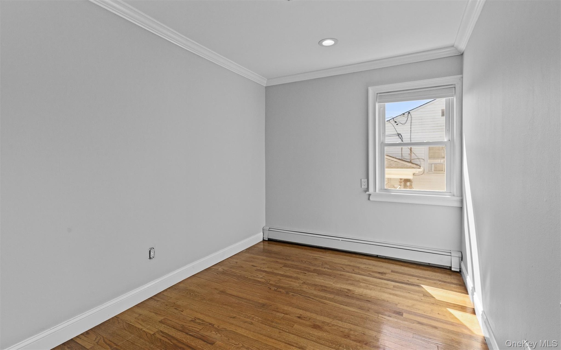 Wood-finish flooring, single window, recessed lighting, white baseboards, and crown molding