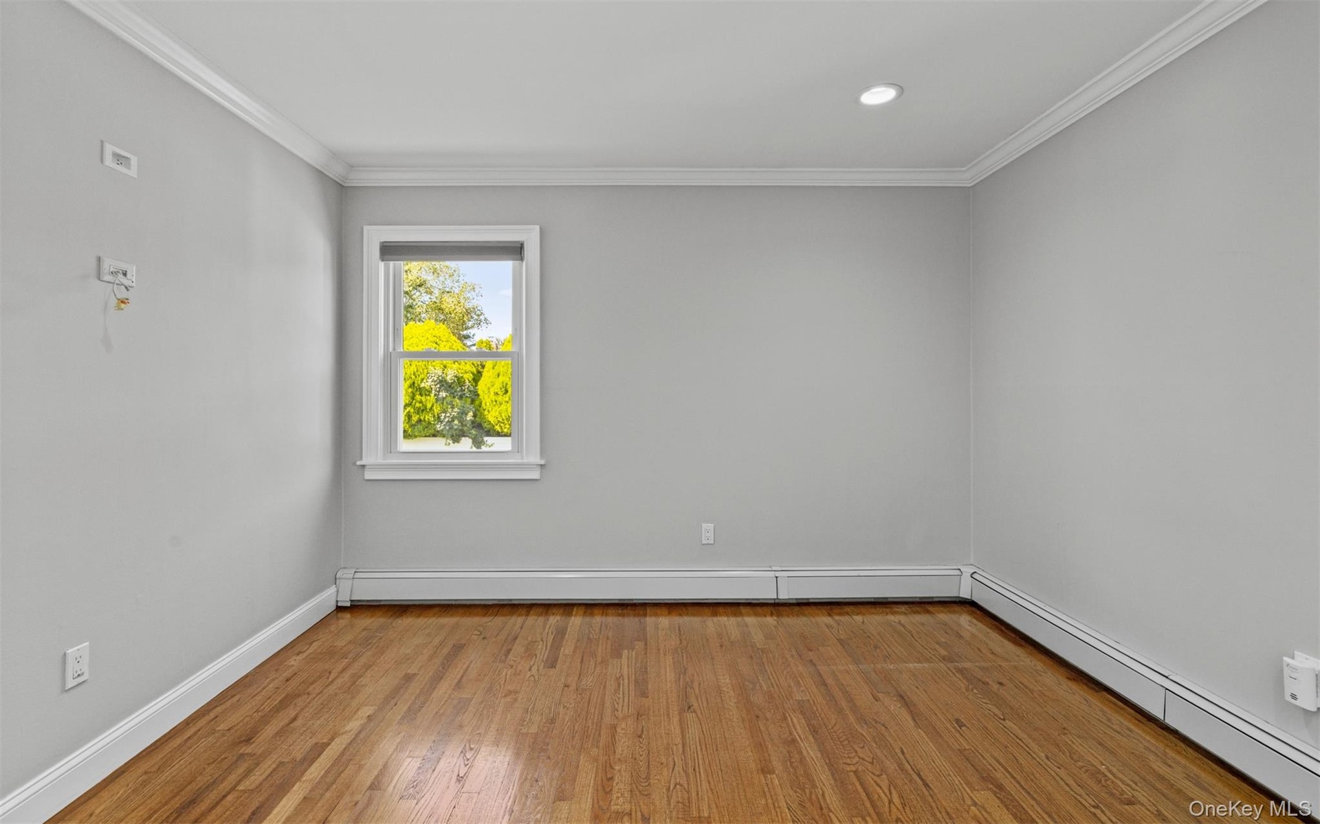 Hardwood flooring, recessed ceiling lighting, crown molding, double-hung window, and baseboard heating