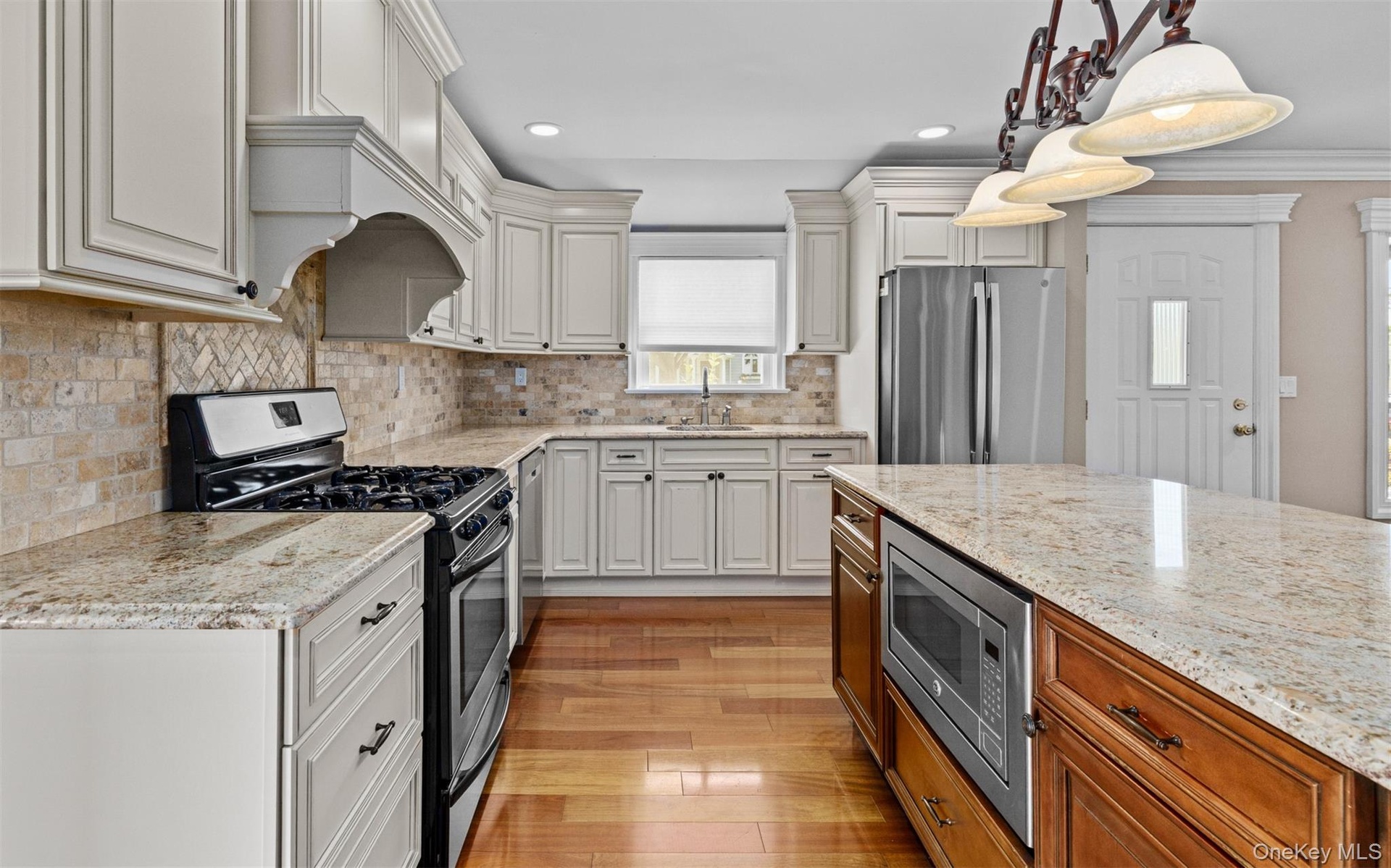 Hardwood flooring, light-toned cabinetry, and stone countertops