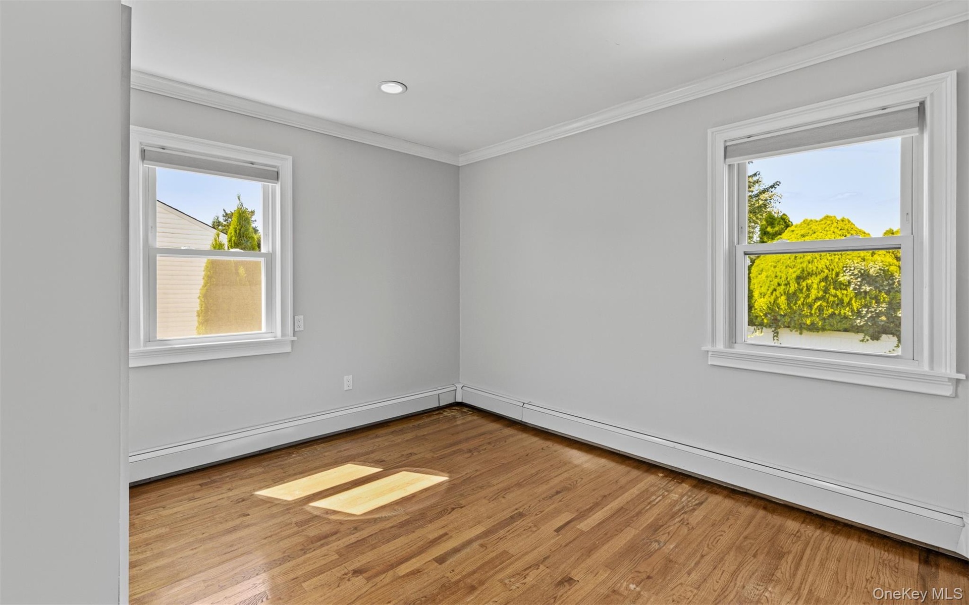 Wood-finish flooring, recessed lighting, and crown molding