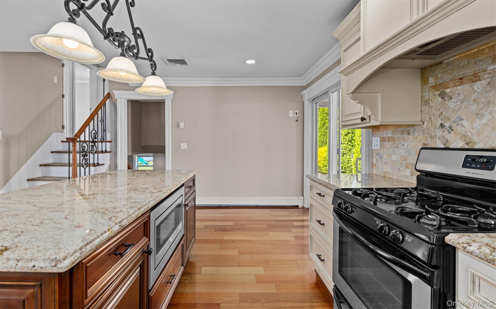 Gourmet kitchen with granite countertops, stainless steel appliances, built-in microwave, and wood-finish flooring