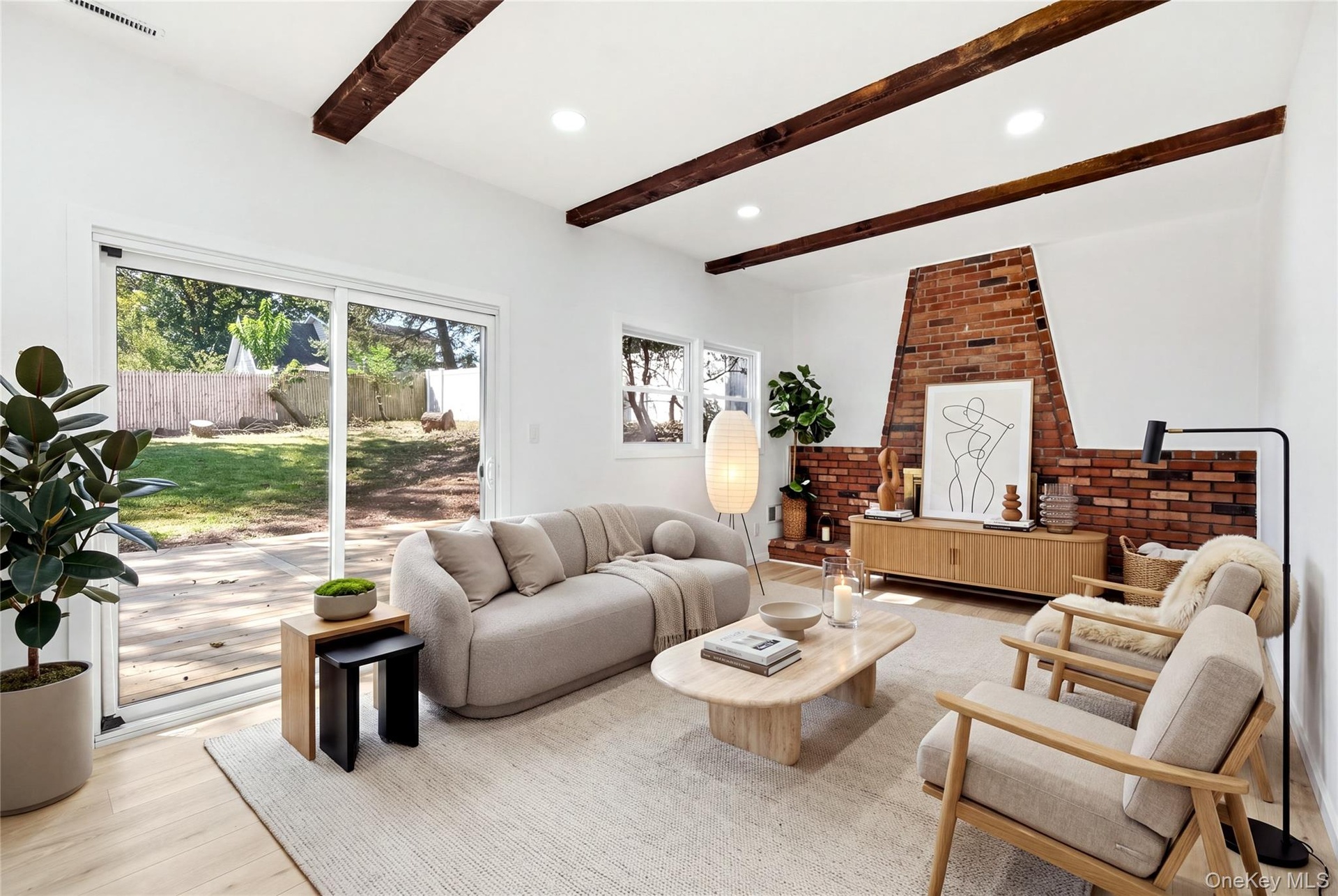 Virtually staged. Exposed ceiling beams, brick fireplace, wood-finish flooring, recessed lighting, and sliding glass door to yard