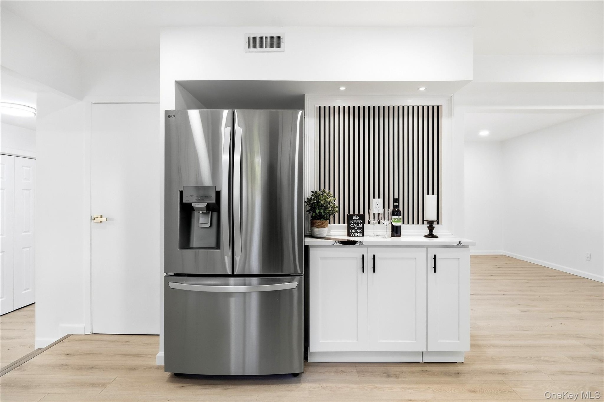 Stainless steel French door refrigerator with bottom freezer and integrated ice/water dispenser. Wine/coffee bar.