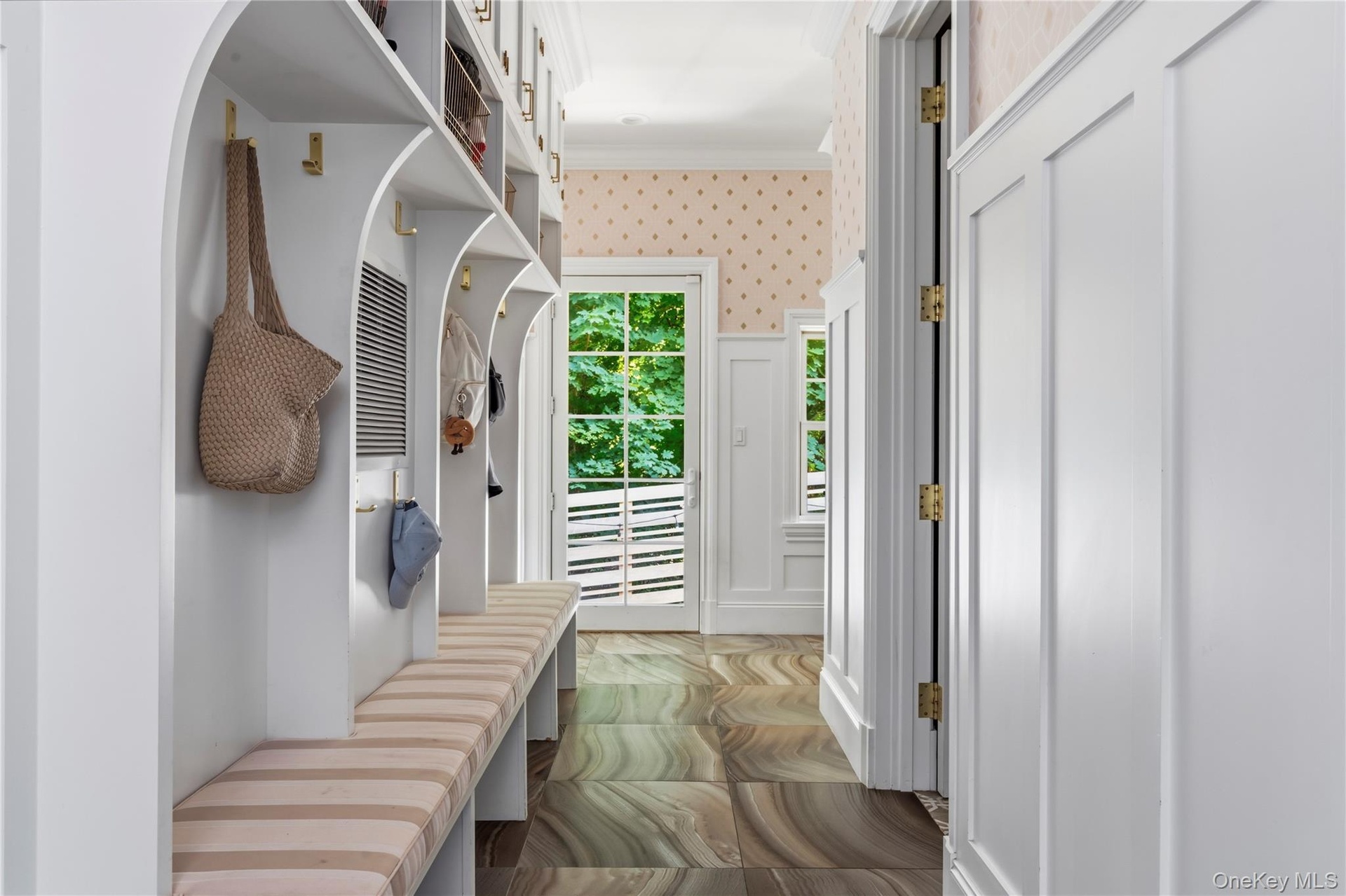 Built-in storage cubbies, half bath and walk-in pantry with garage access