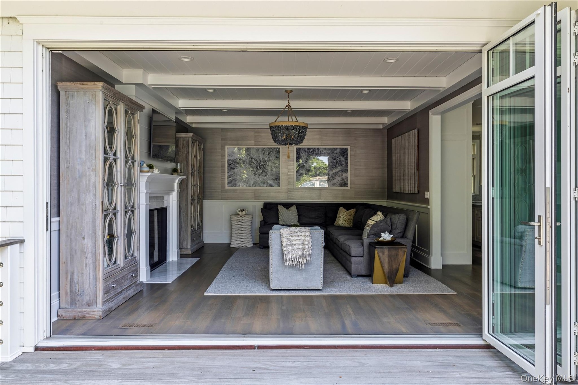 Folding glass panel doors from den to deck for seamless indoor and outdoor living