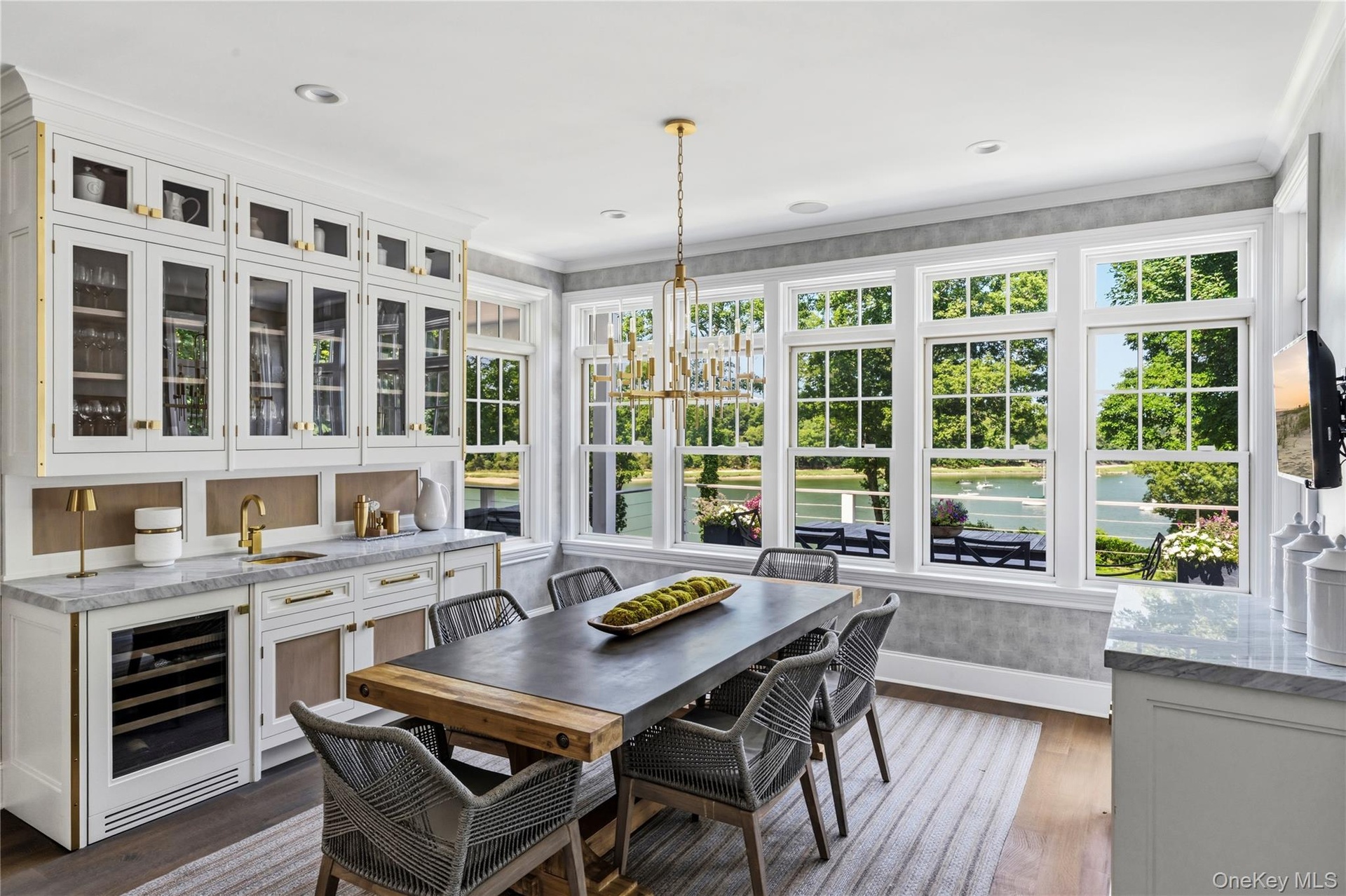 Built-in cabinetry with glass panel doors, integrated beverage cooler, and waterviews.