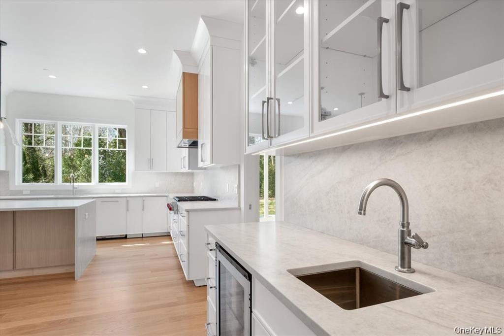 Butlers pantry is outfitted with sink and beverage cooler and links the kitchen to the dining room