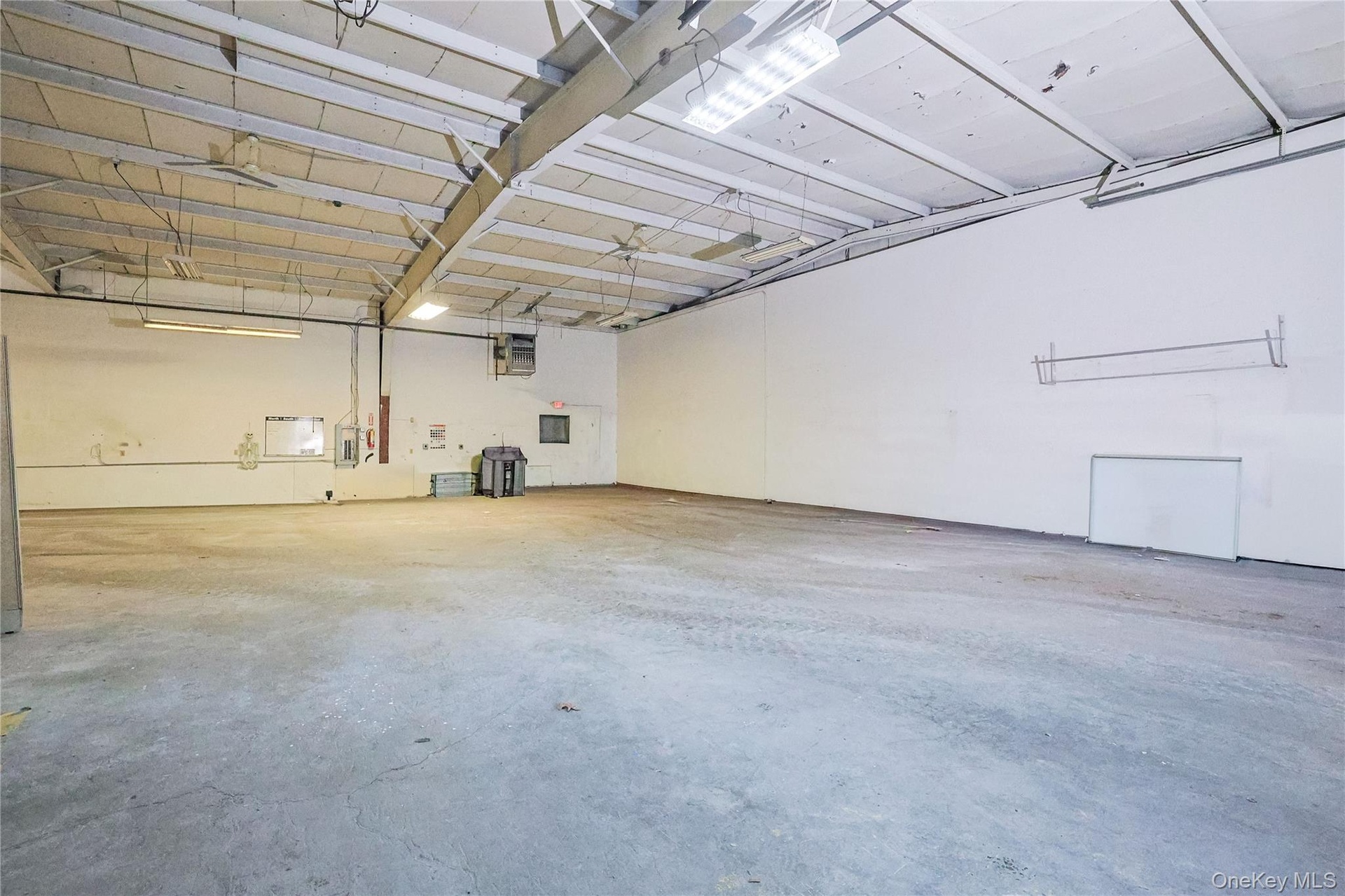 Garage featuring a heating unit and electric panel