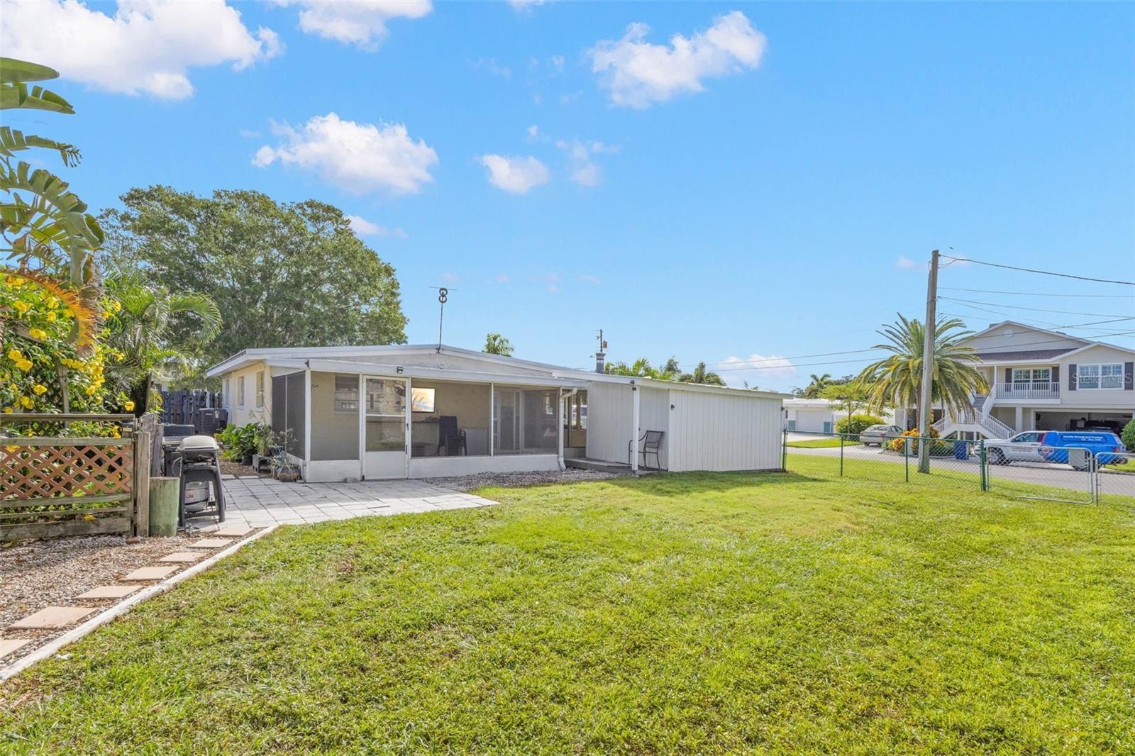 A spacious screened lanai extends across the rear of the home, offering plenty of covered space for relaxing, dining, and enjoying the backyard.