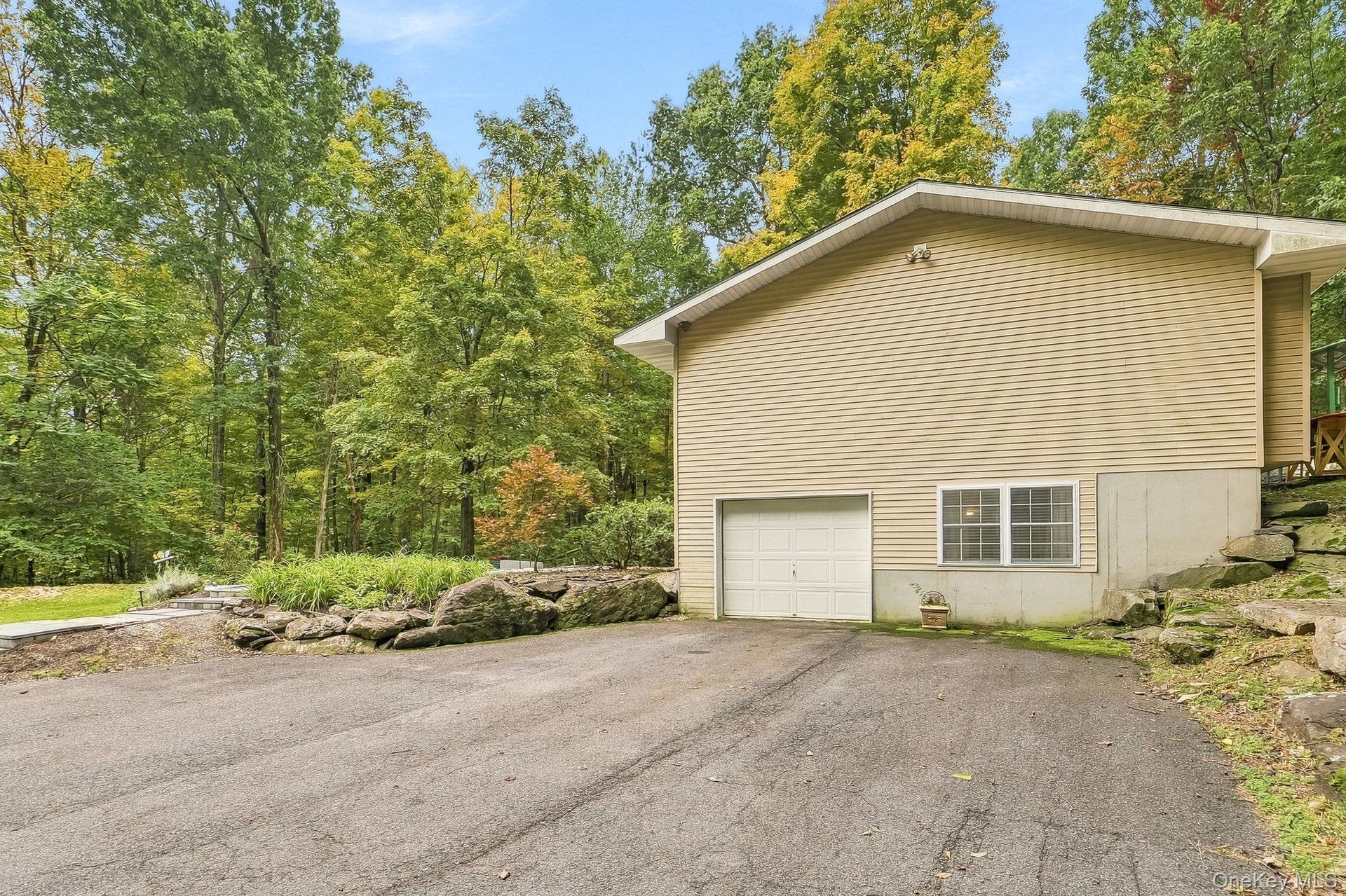 Siding exterior with a built-in garage and white garage door