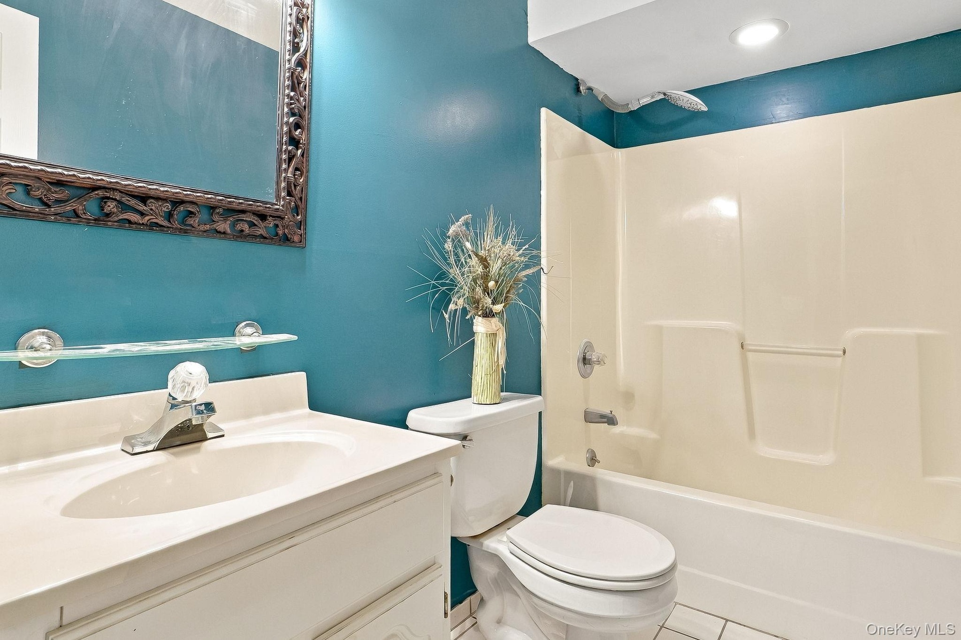 Integrated vanity with a single basin sink, wall-mounted mirror, and tub/shower combination