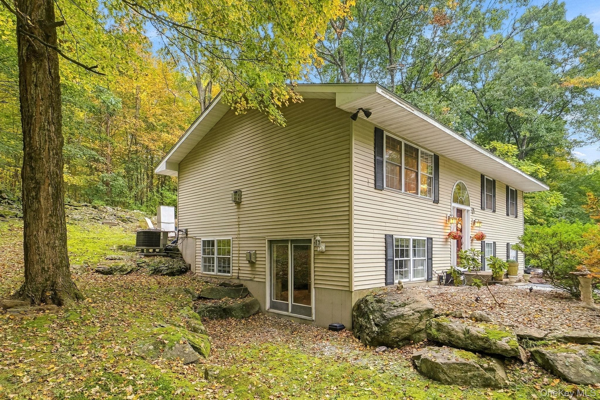 Two-story exterior with light-colored siding and dark window shutters