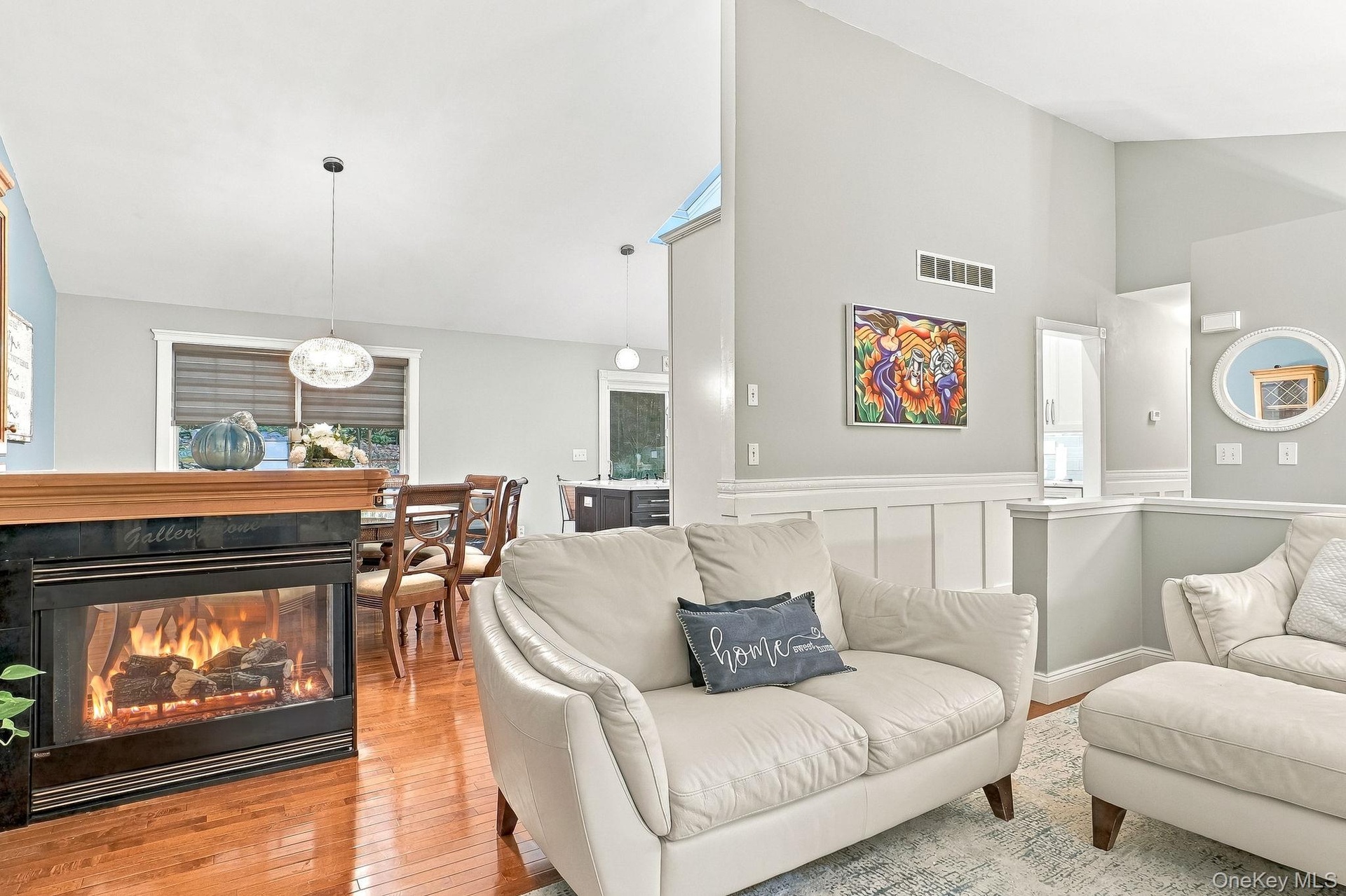 Hardwood flooring, a built-in fireplace with a stone and modern lighting