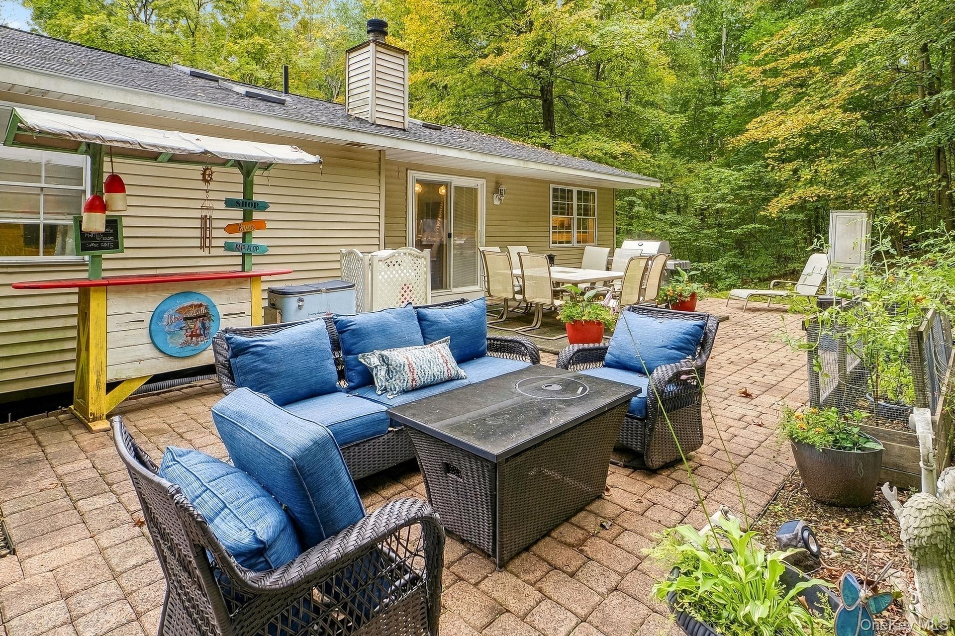 Expansive paver patio with a built-in outdoor Tiki bar and a large outdoor dining area