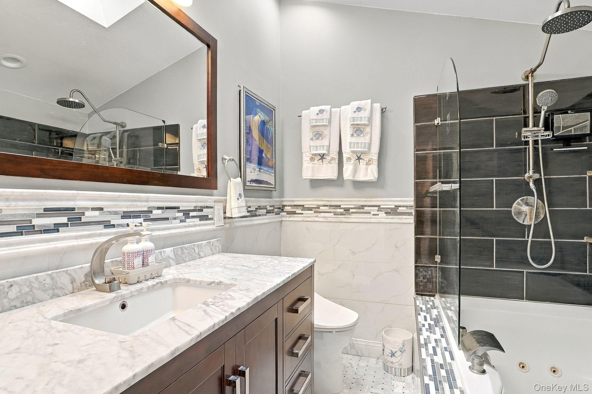 White undermount sink with a single-handle faucet, set into a marble-look countertop