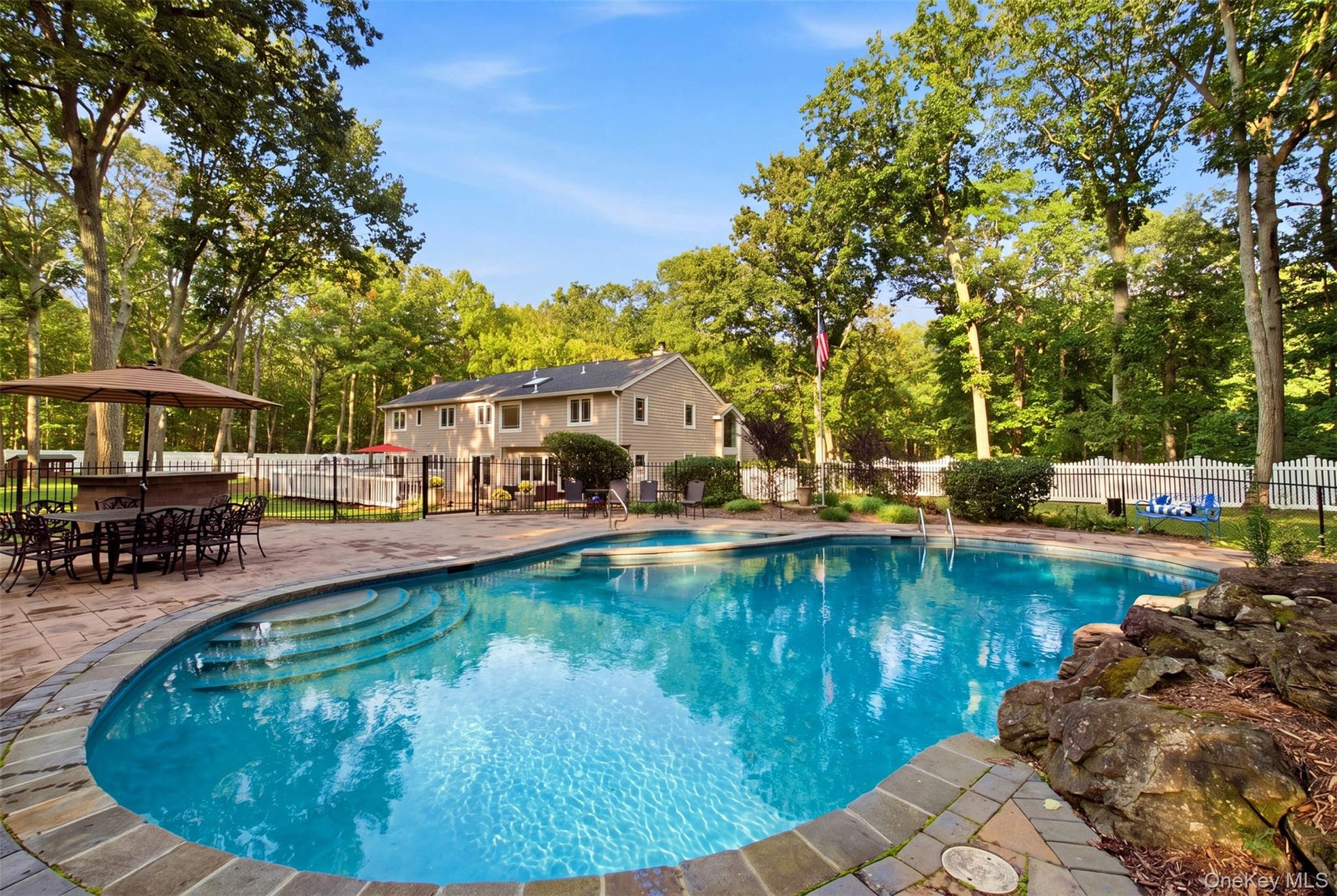 Poolside bar has granite top with a sink and refrigerator