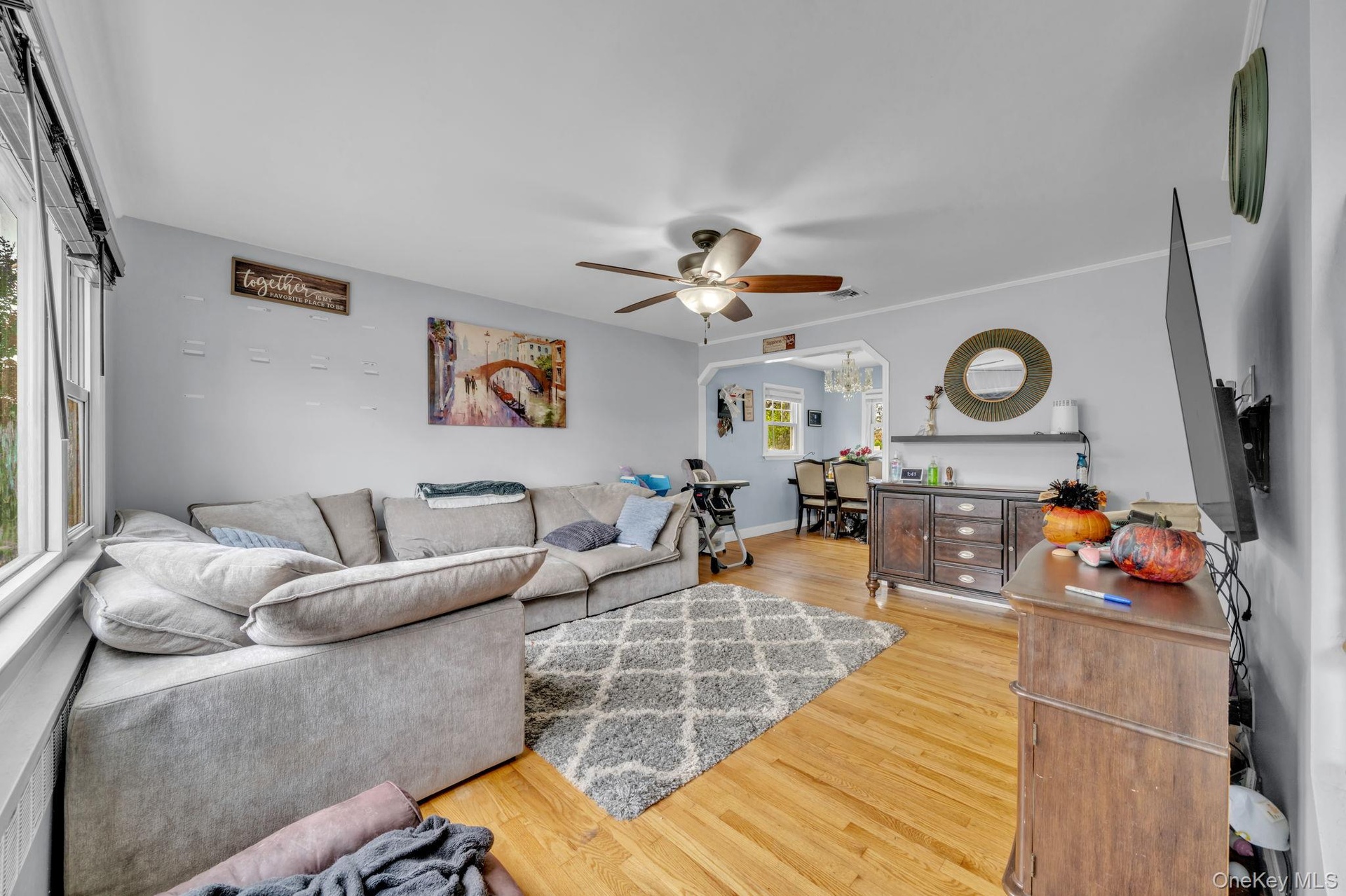 Hardwood flooring throughout, with a ceiling fan light fixture.