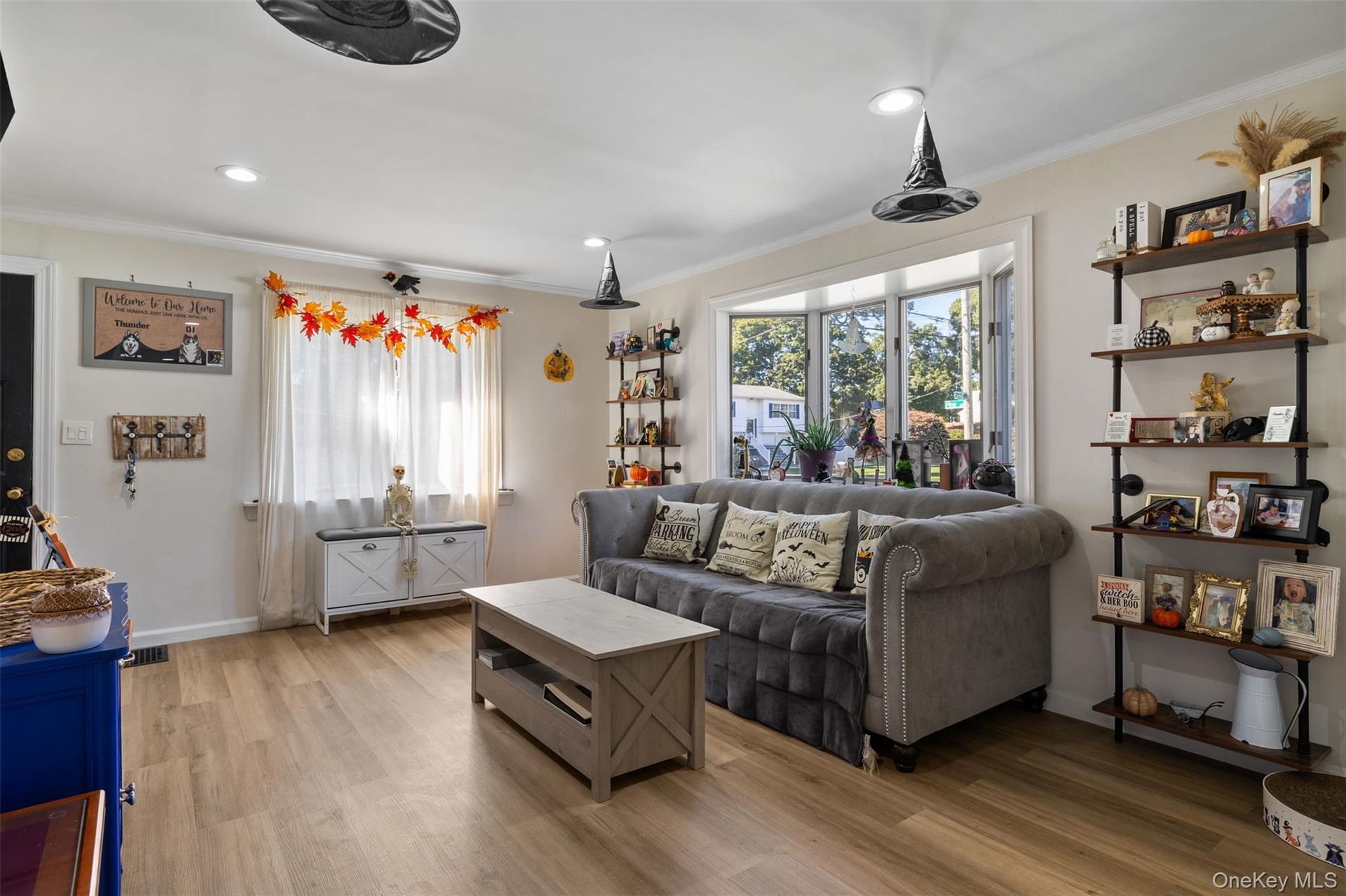 Bay window with multiple panes, wood-finish flooring, recessed lighting, and built-in shelving