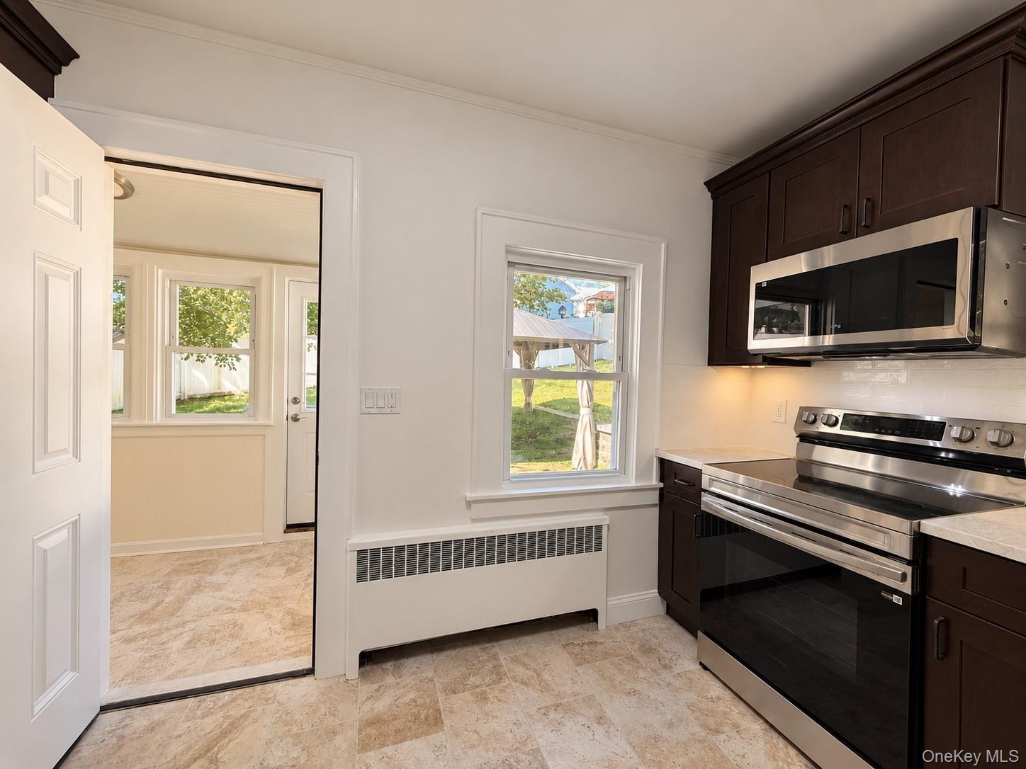 Rich wood-finish cabinetry, new stainless steel appliances, and wood-finish flooring