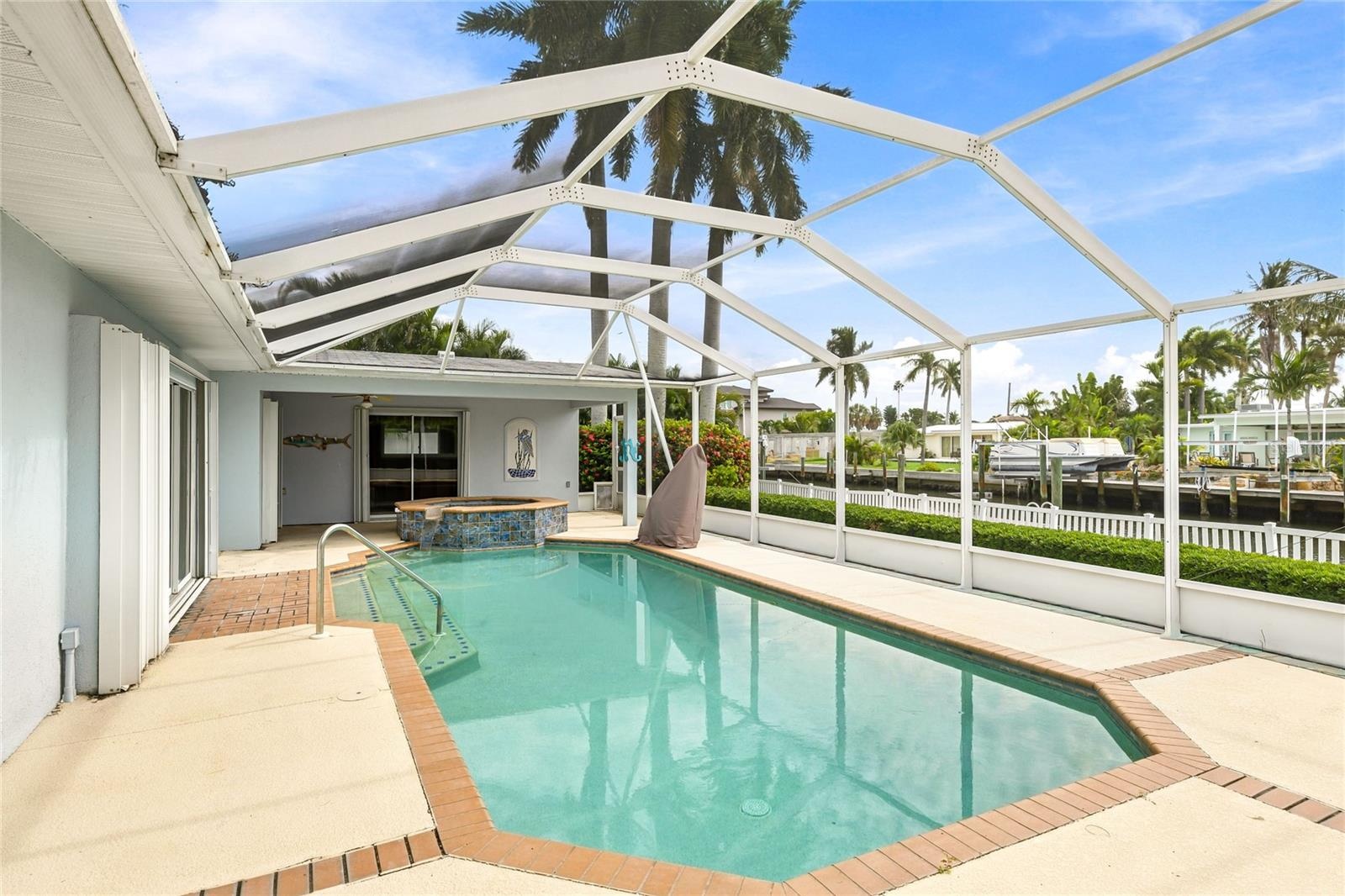 Screened pool and spa area near the dock and canal