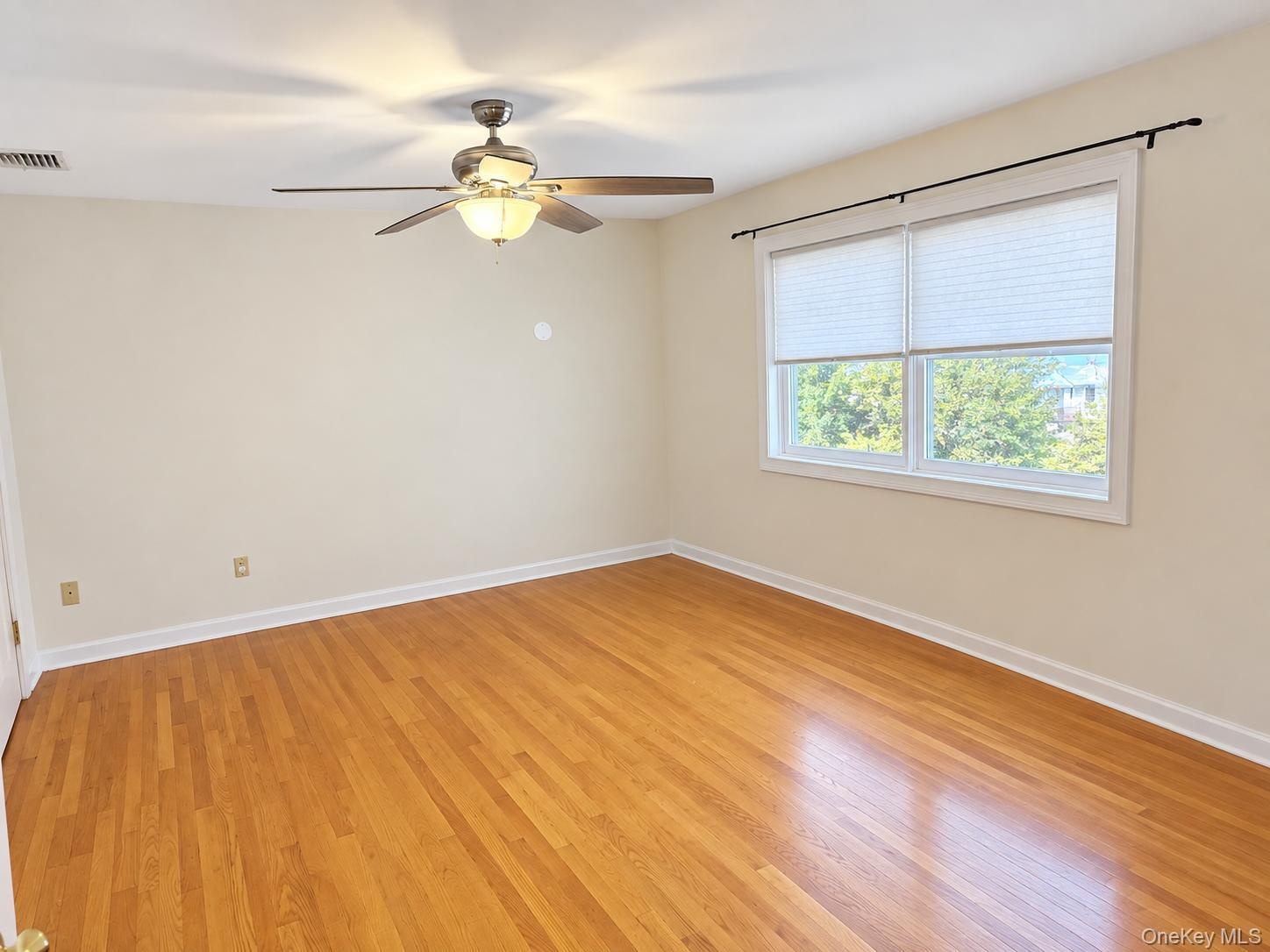 Hardwood flooring, white trim, and a ceiling fan with integrated lighting