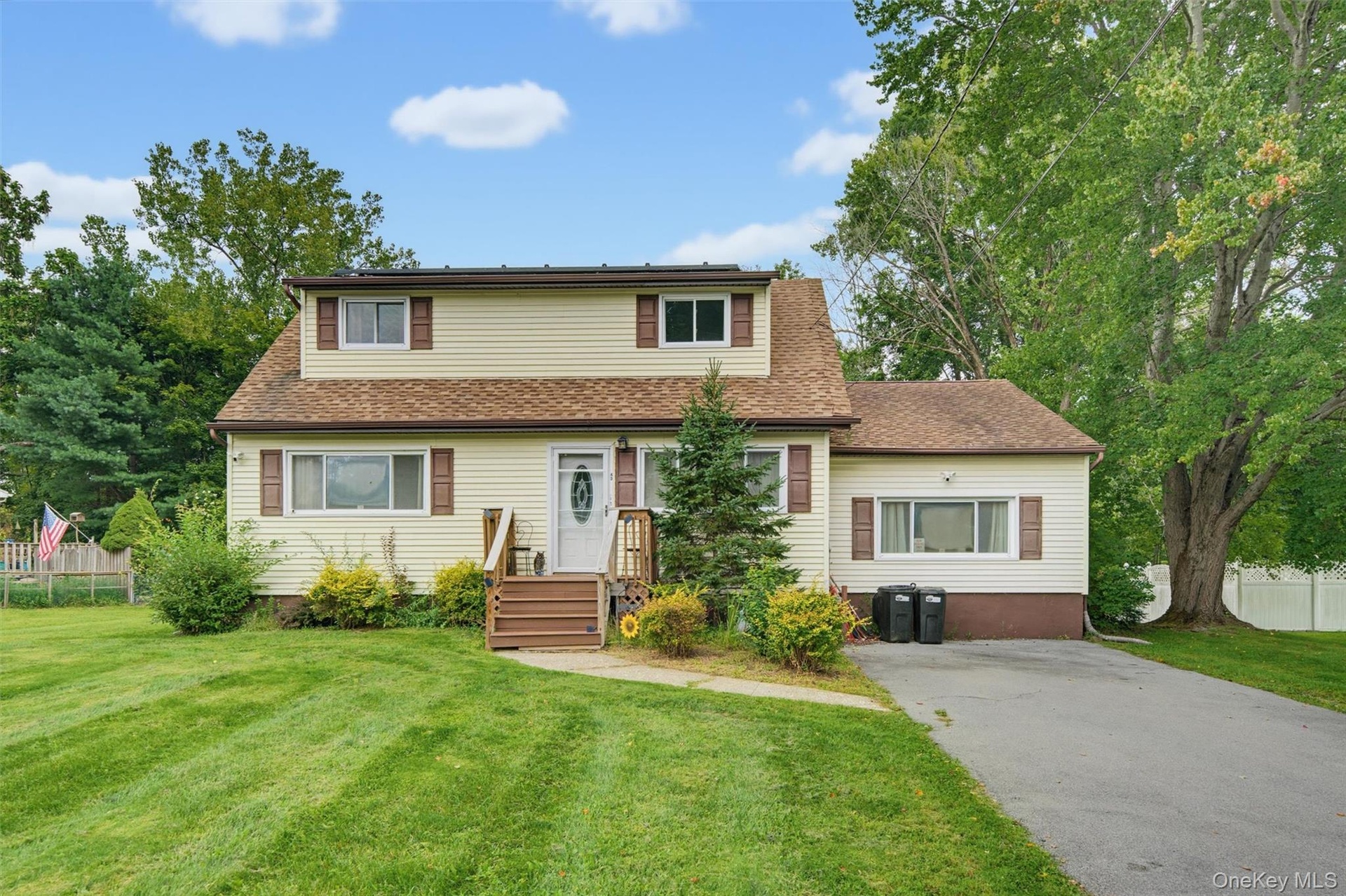 Two-story residence with light-colored siding and brown window shutters