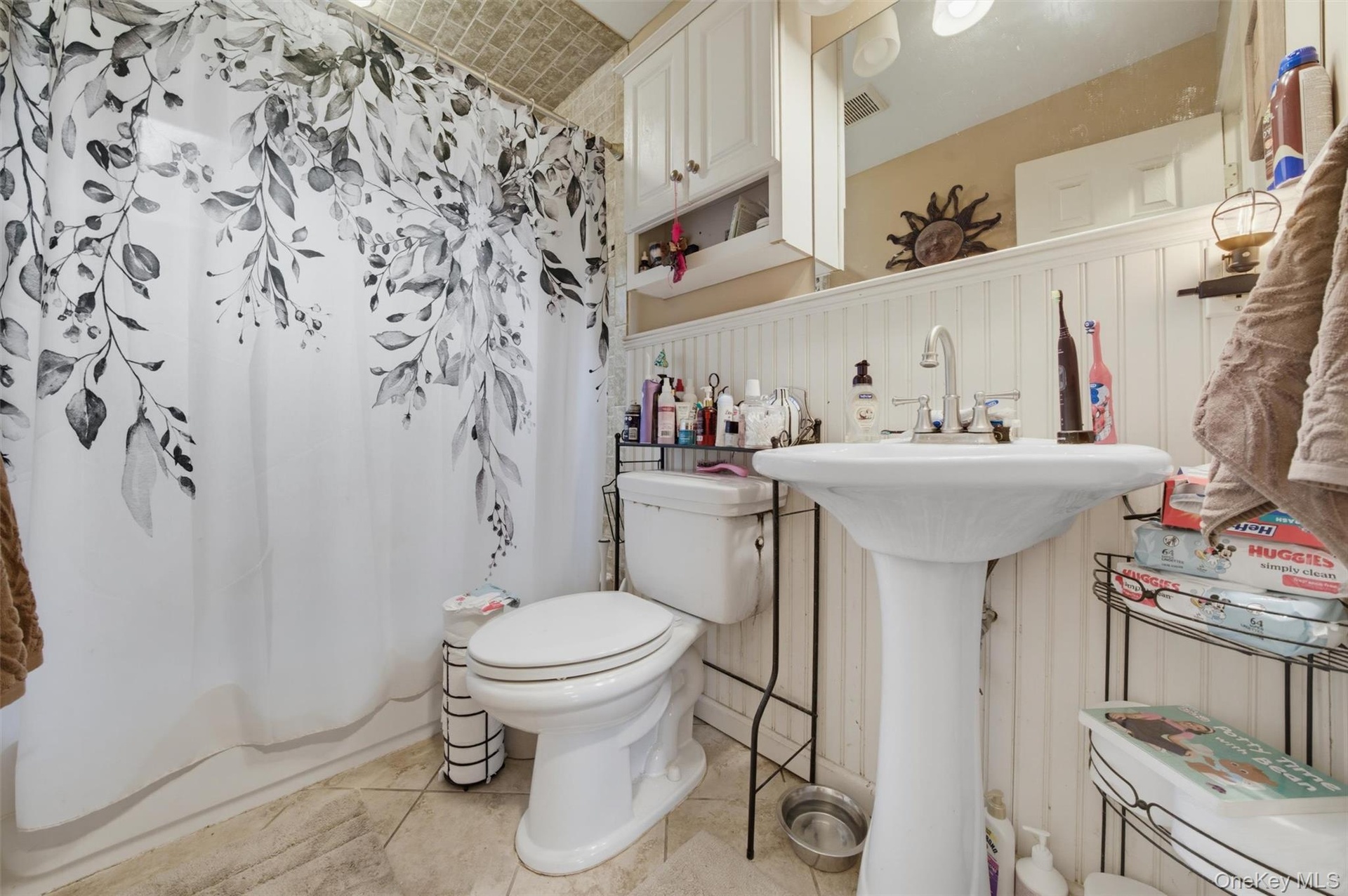 Bathroom with sink, bathtub with chrome fixtures and a vanity mirror
