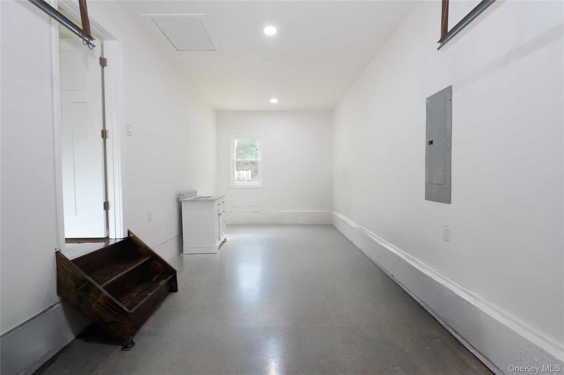 Spacious interior with concrete flooring and recessed lighting