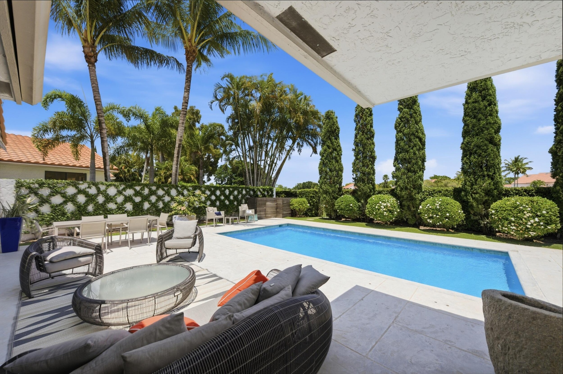 Covered patio and poolside seating in Wellington FL luxury rental home