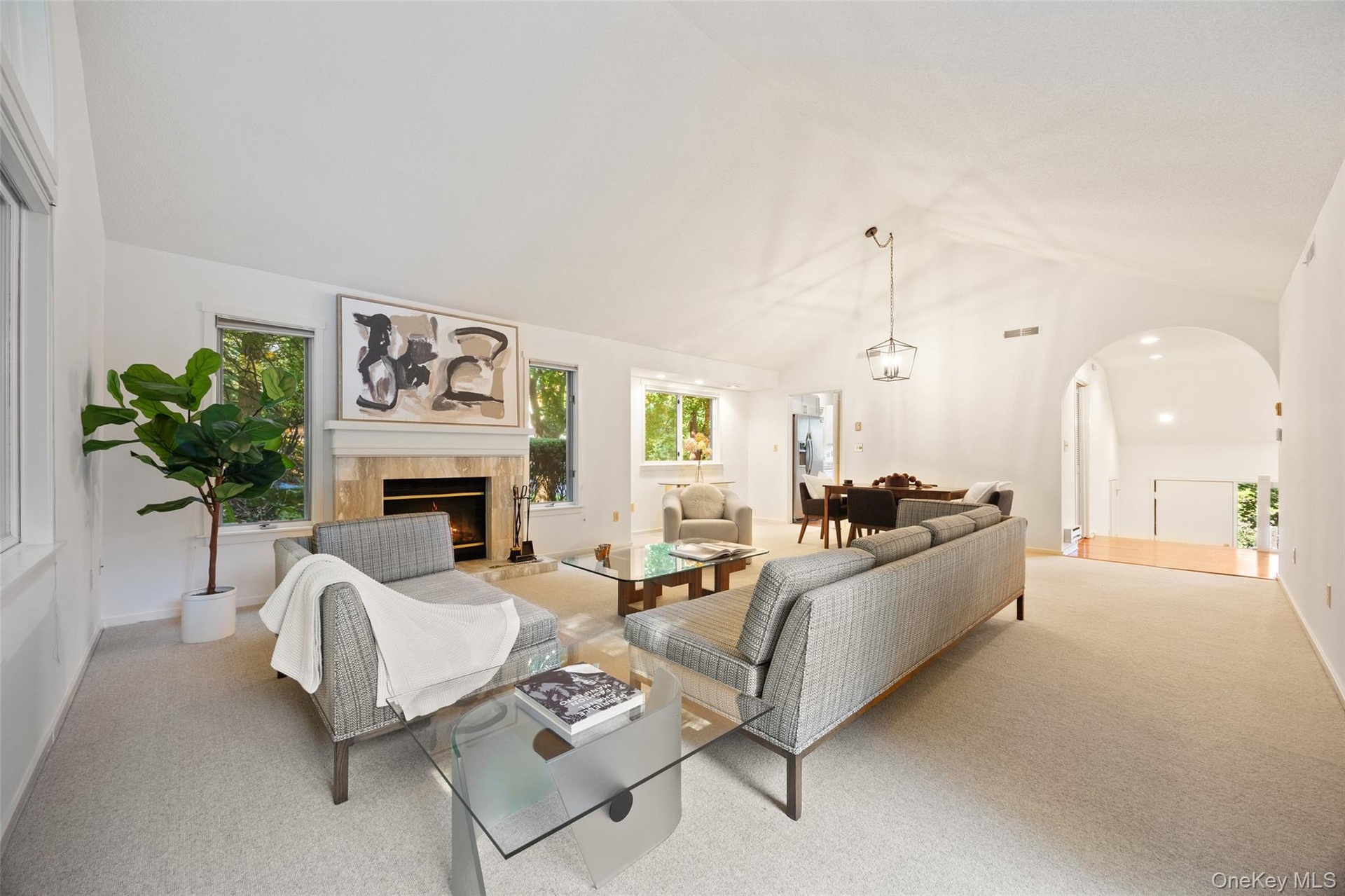 High ceilings, stone fireplace surround, abundant natural light, & understated elegance.