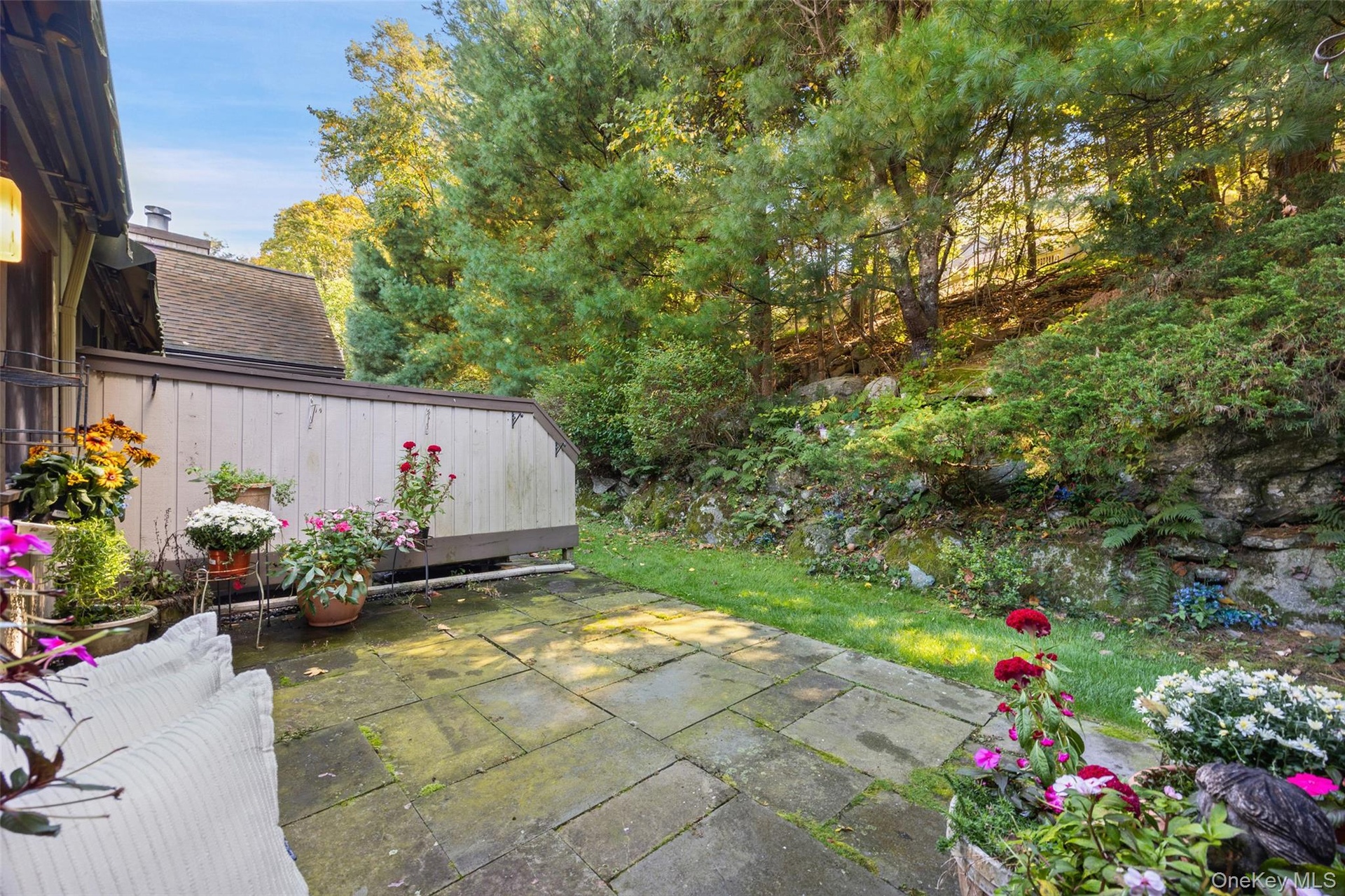 Secluded private blue stone patio overlooking lush greenery.