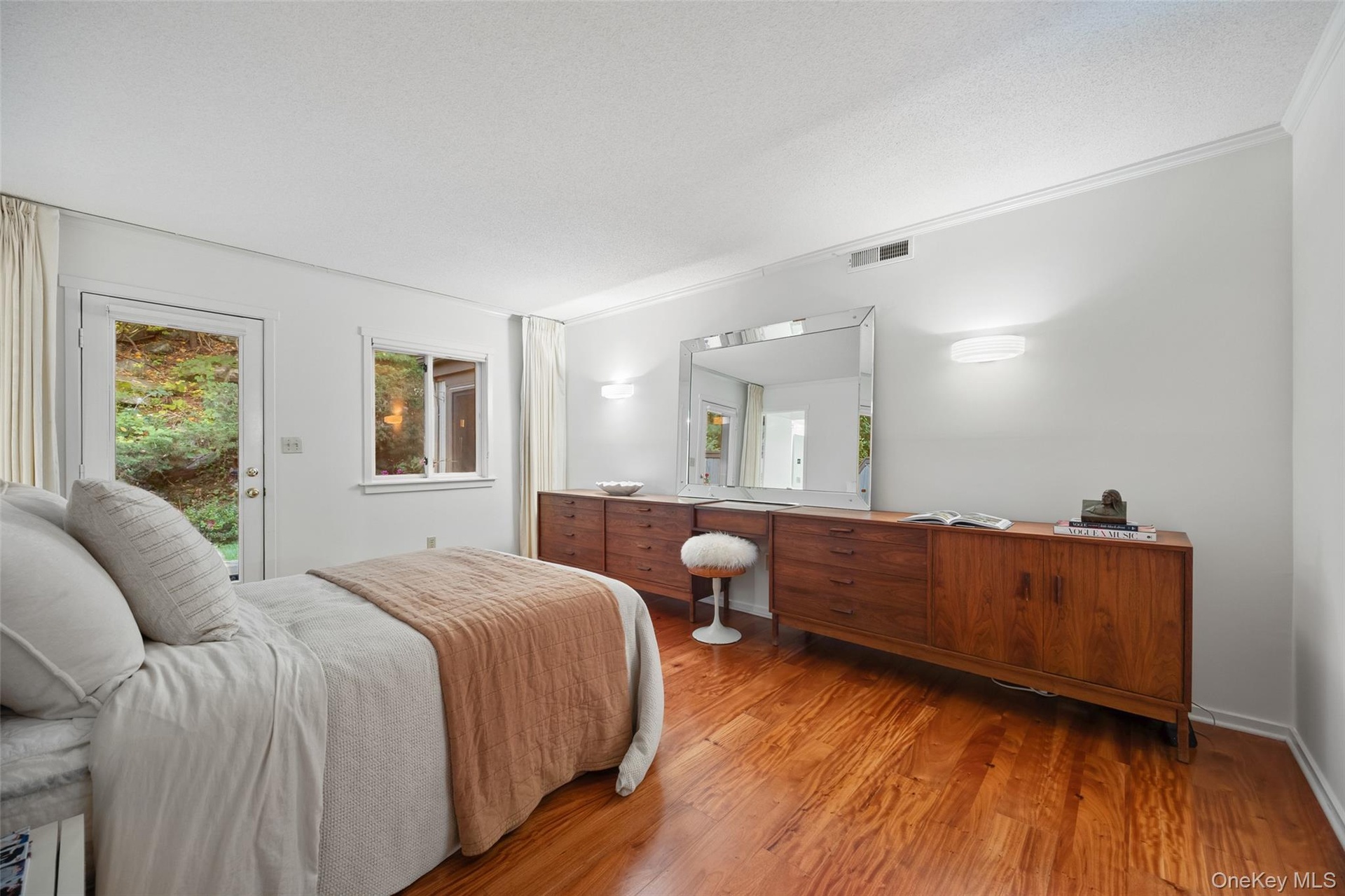 King-sized primary bedroom with large closet, ensuite bathroom, and additional exit to the private patio.