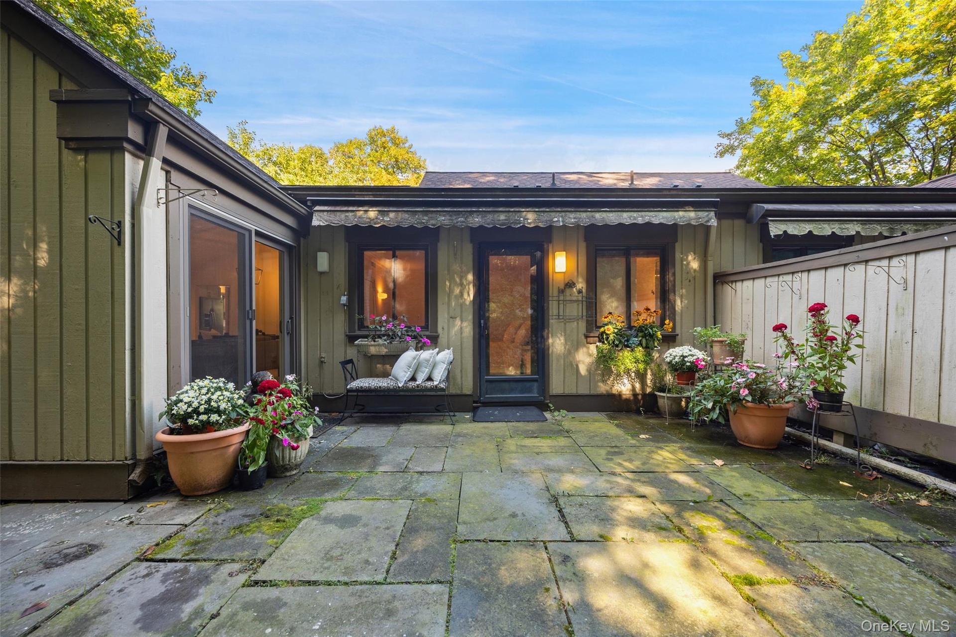 Secluded private blue stone patio overlooking lush greenery.