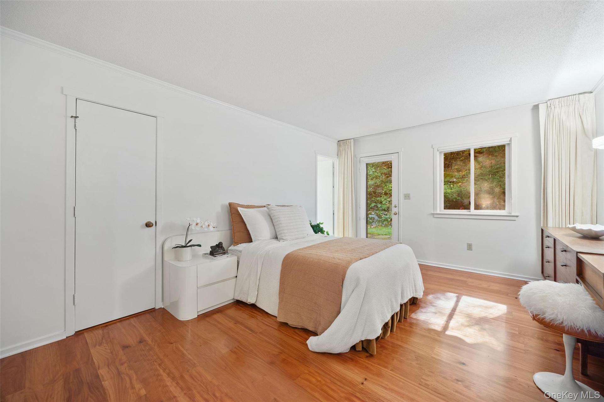 King-sized primary bedroom with large closet, ensuite bathroom, and additional exit to the private patio.