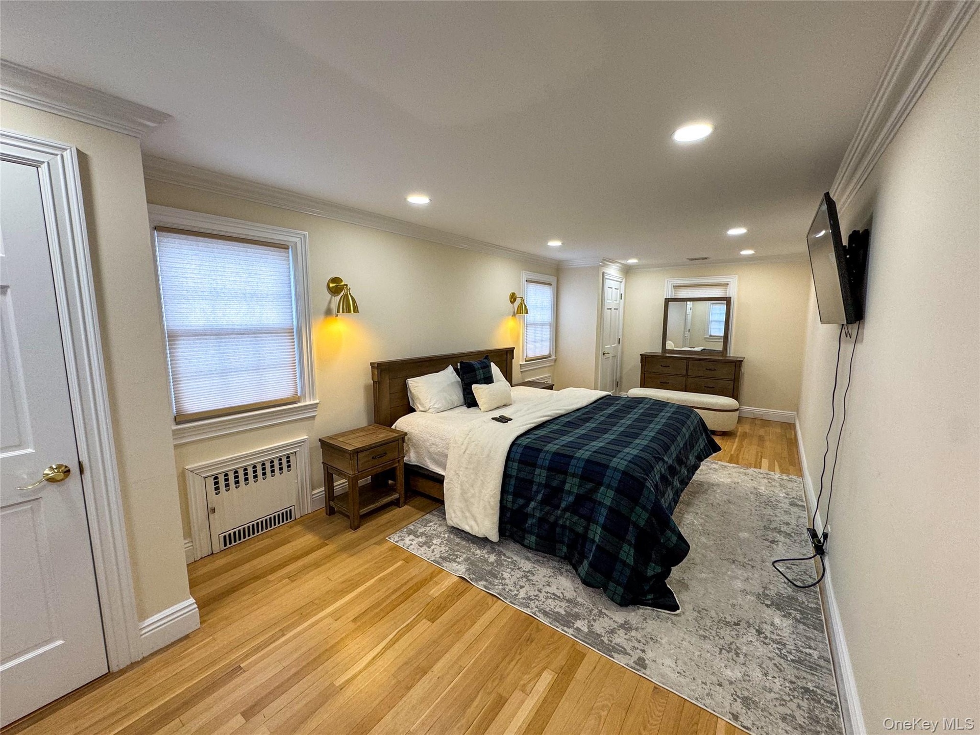 Hardwood flooring, recessed lighting, crown molding, wall-mounted light fixtures, and white paneled doors