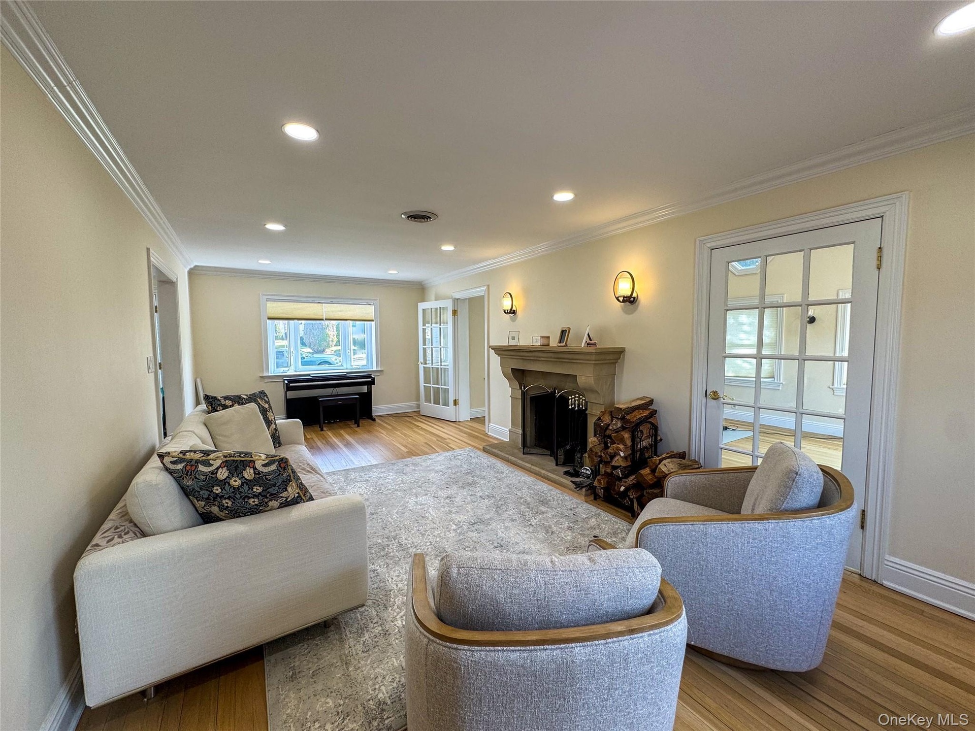 Recessed lighting, crown molding, wood-finish flooring, stone fireplace, and French doors