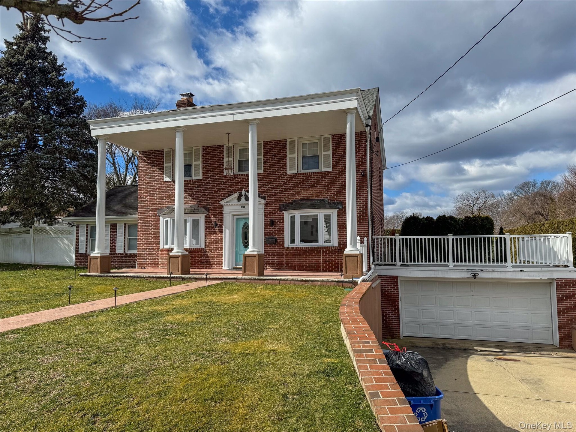 Brick exterior with a prominent portico featuring round columns, 2 car garage