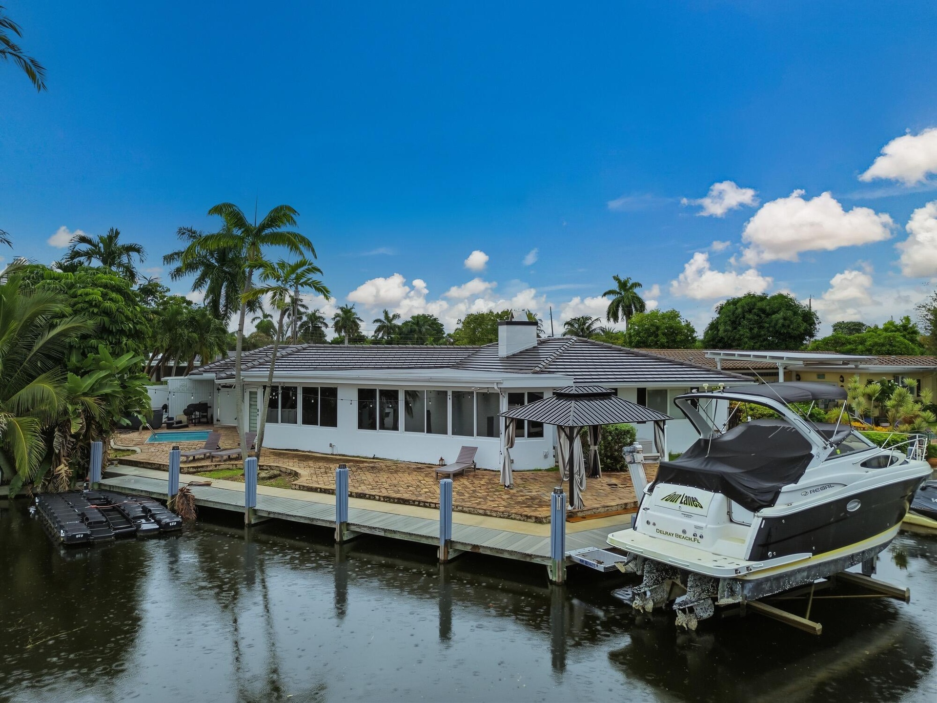 Waterfront property with a private dock featuring pilings, a boat lift, and an additional floating dock system