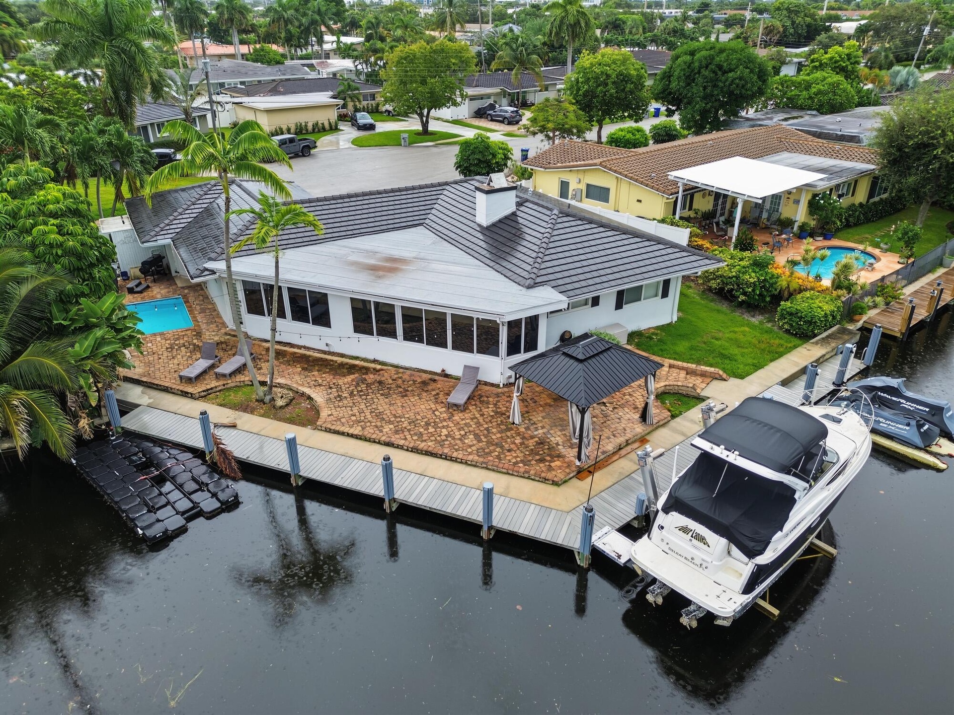 Waterfront property featuring a private boat lift, a dock, and a swimming pool