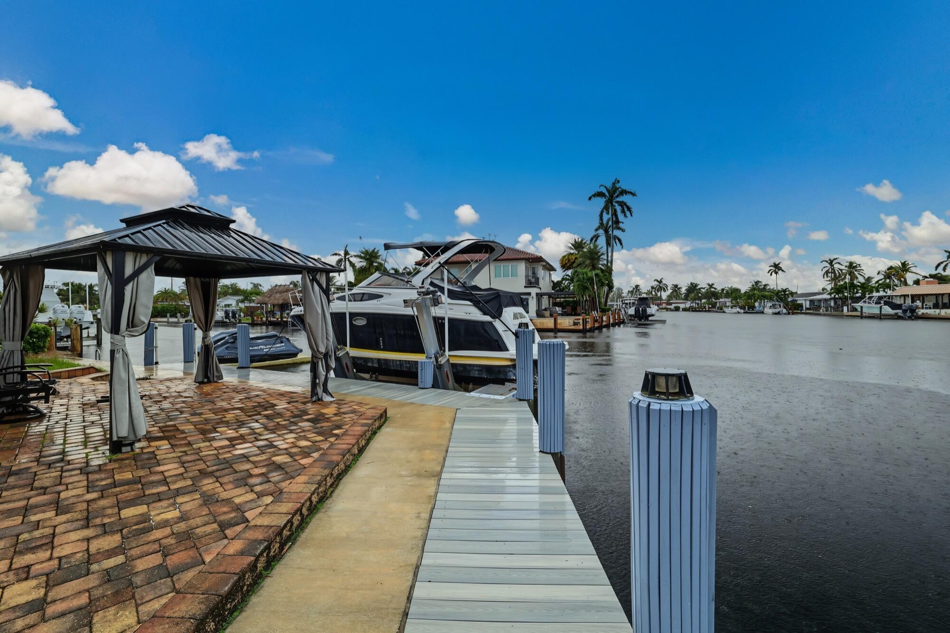 Waterfront property with private dock, paver patio, and covered gazebo