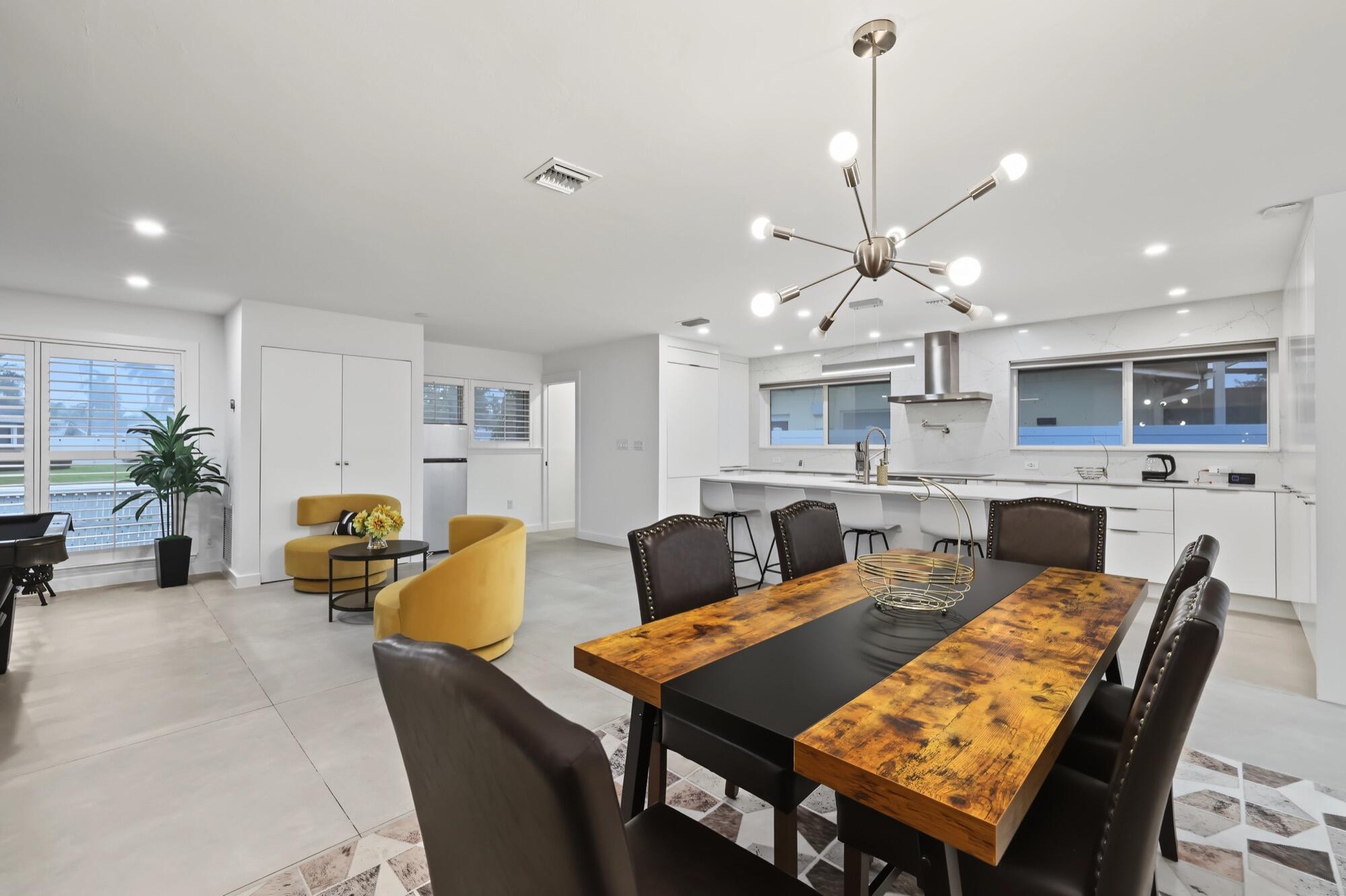 Open-concept living space with recessed lighting and a modern chandelier