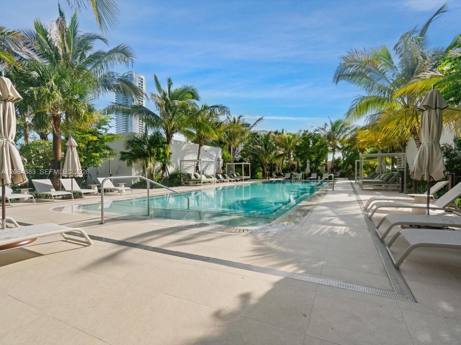 One-acre rooftop amenity deck with resort-style pool, cabanas and tropical landscaping