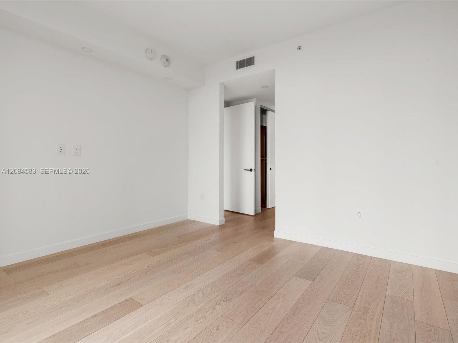 Primary bedroom with engineered wood flooring