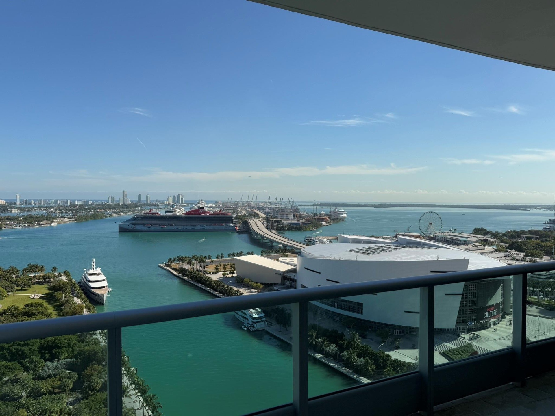 Expansive water and city views from a private balcony with a glass and metal railing