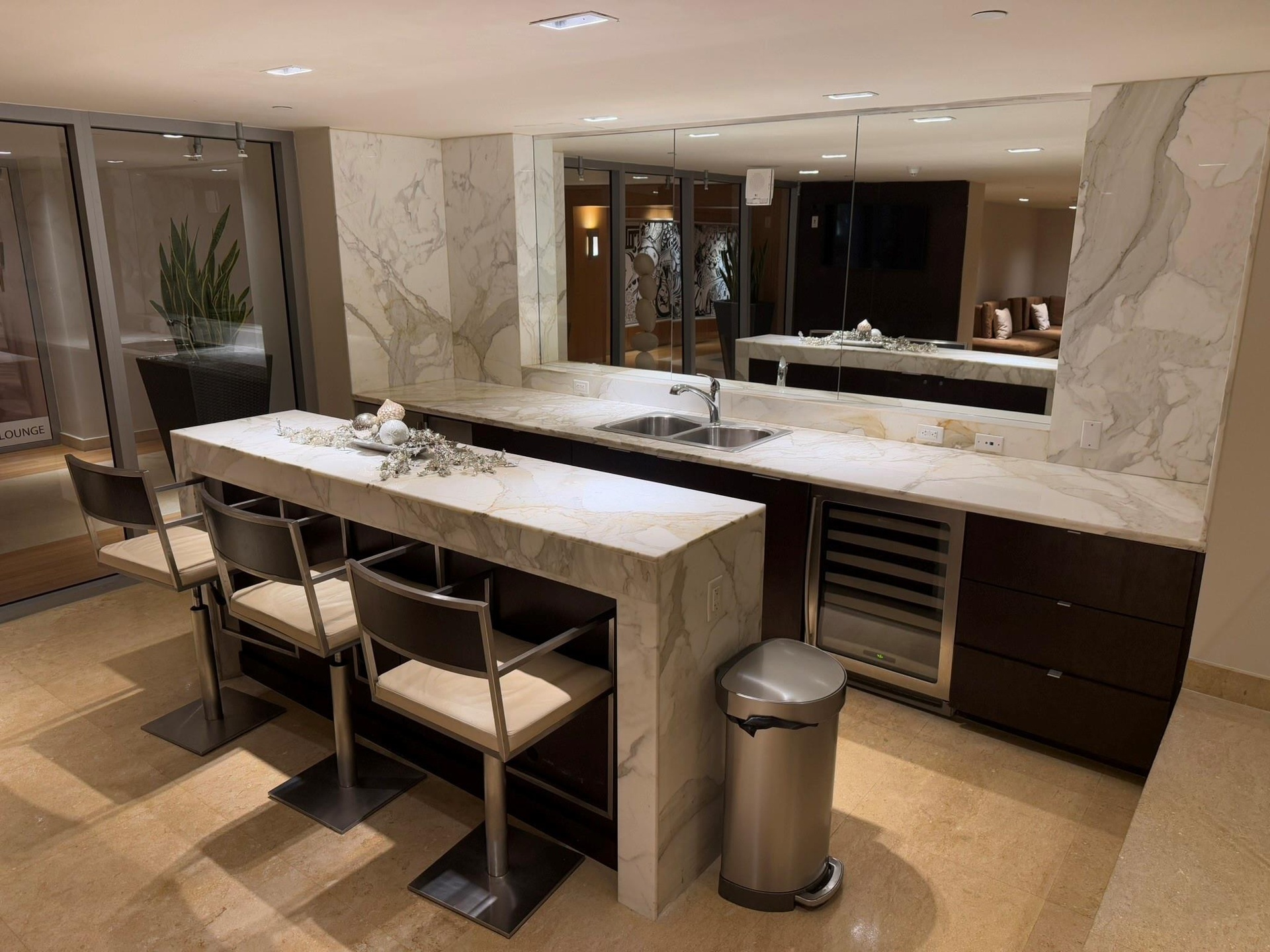 Wet bar featuring stone countertops and backsplash, integrated wine cooler, double basin sink, and recessed lighting