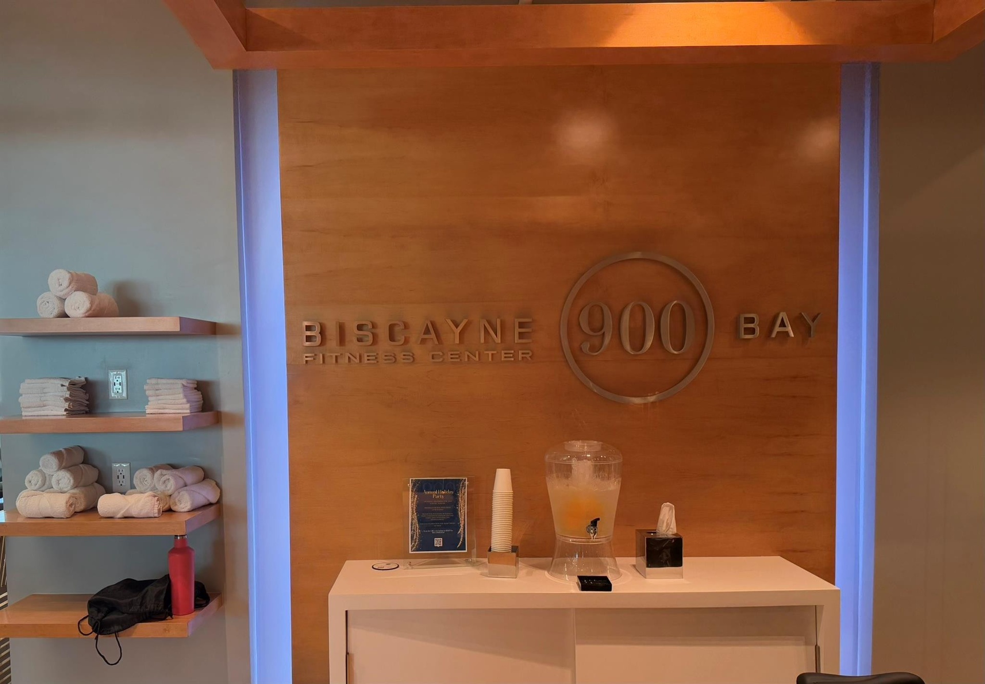 Fitness center reception area featuring a wood-panel accent wall with dimensional signage