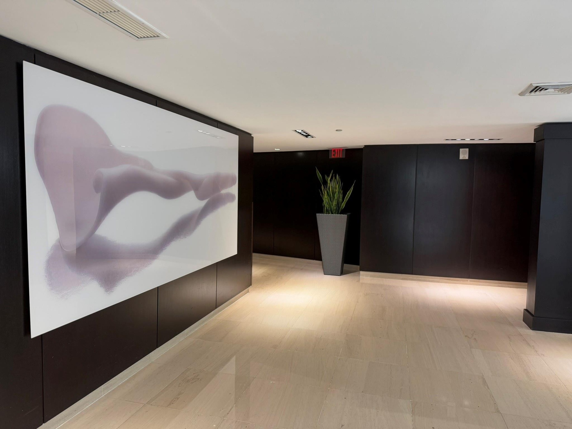 Polished tile flooring with dark wood-paneled walls and a large illuminated art panel
