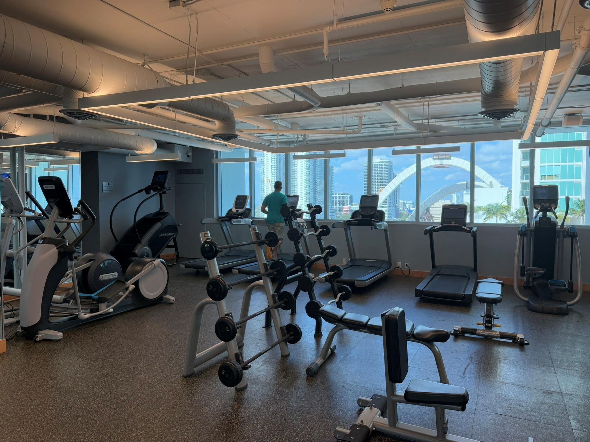 Fitness center featuring multiple treadmills, elliptical machines, and free weights
